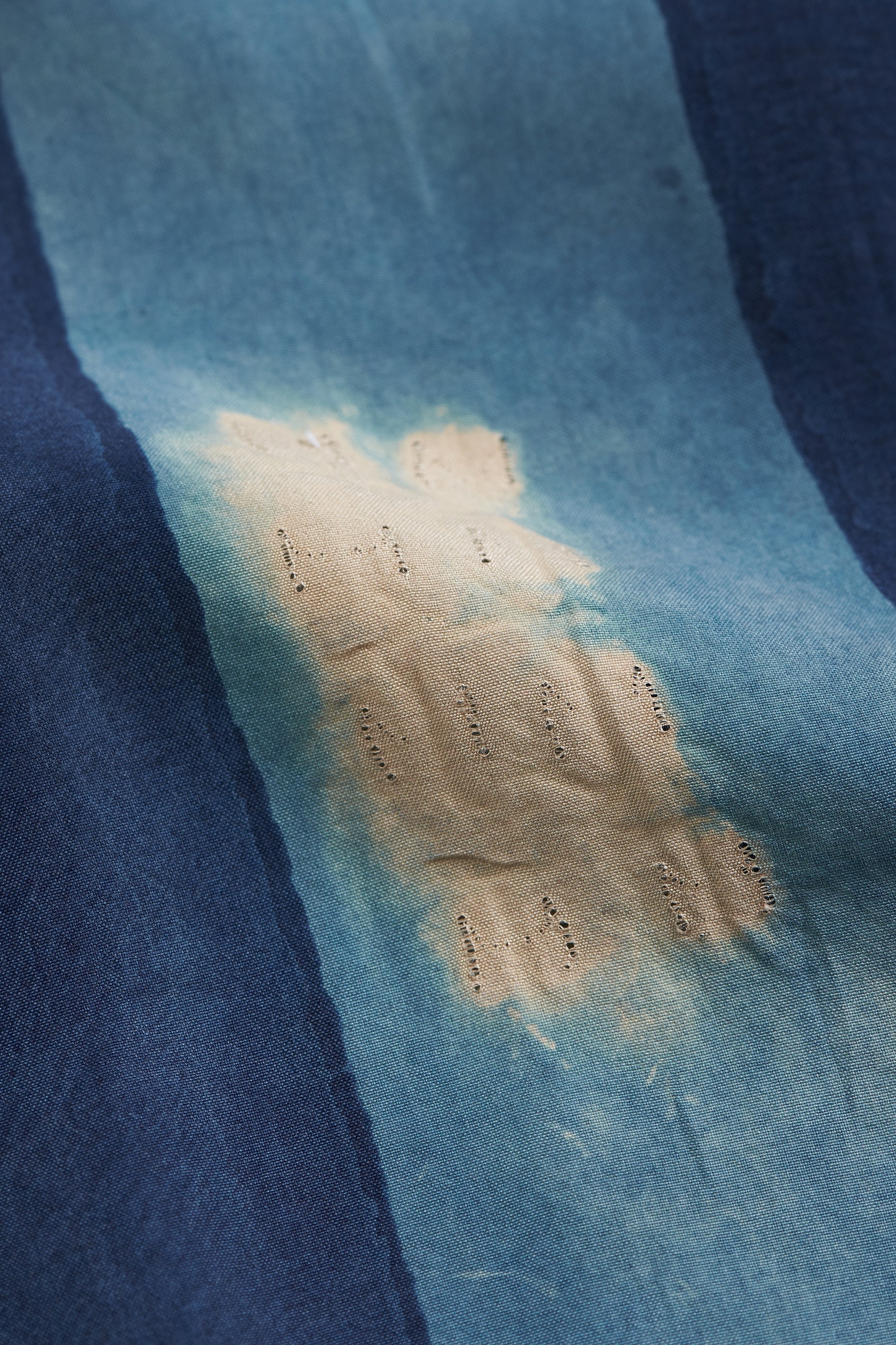 Blue fabric with a large yellowish stain