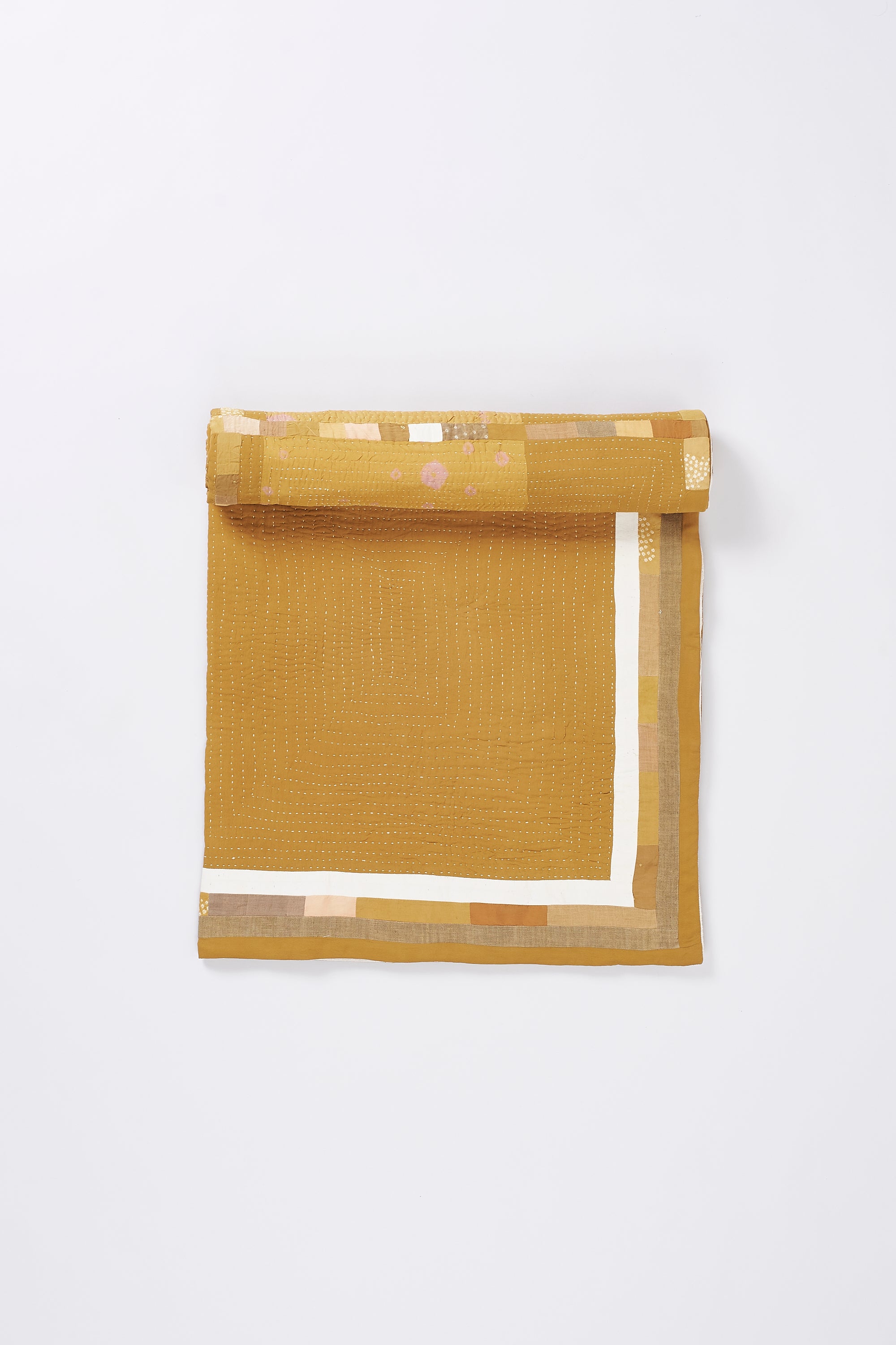 Ochere yellow quilt roll on a white background