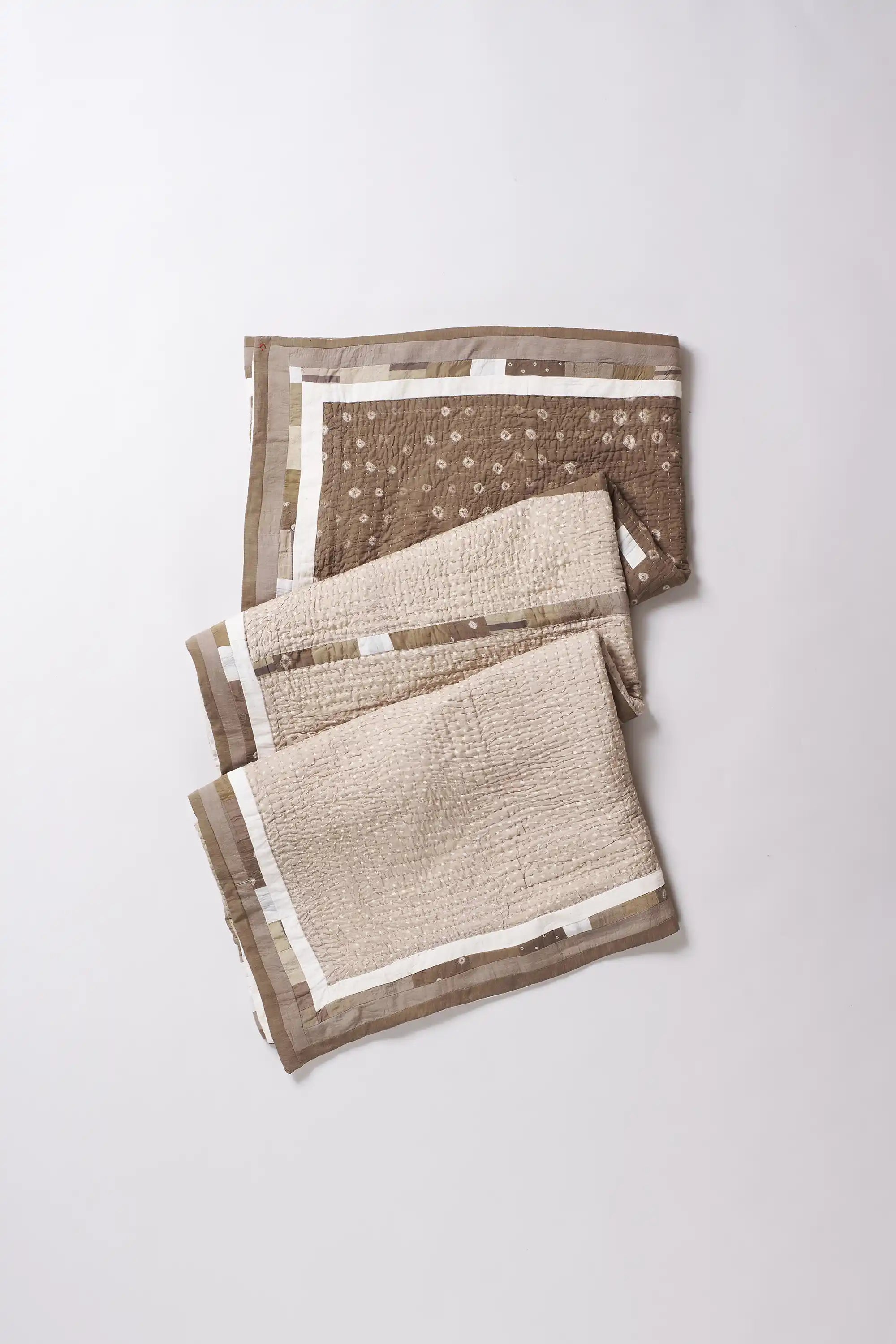 Folded quilt with different patterns on a white background