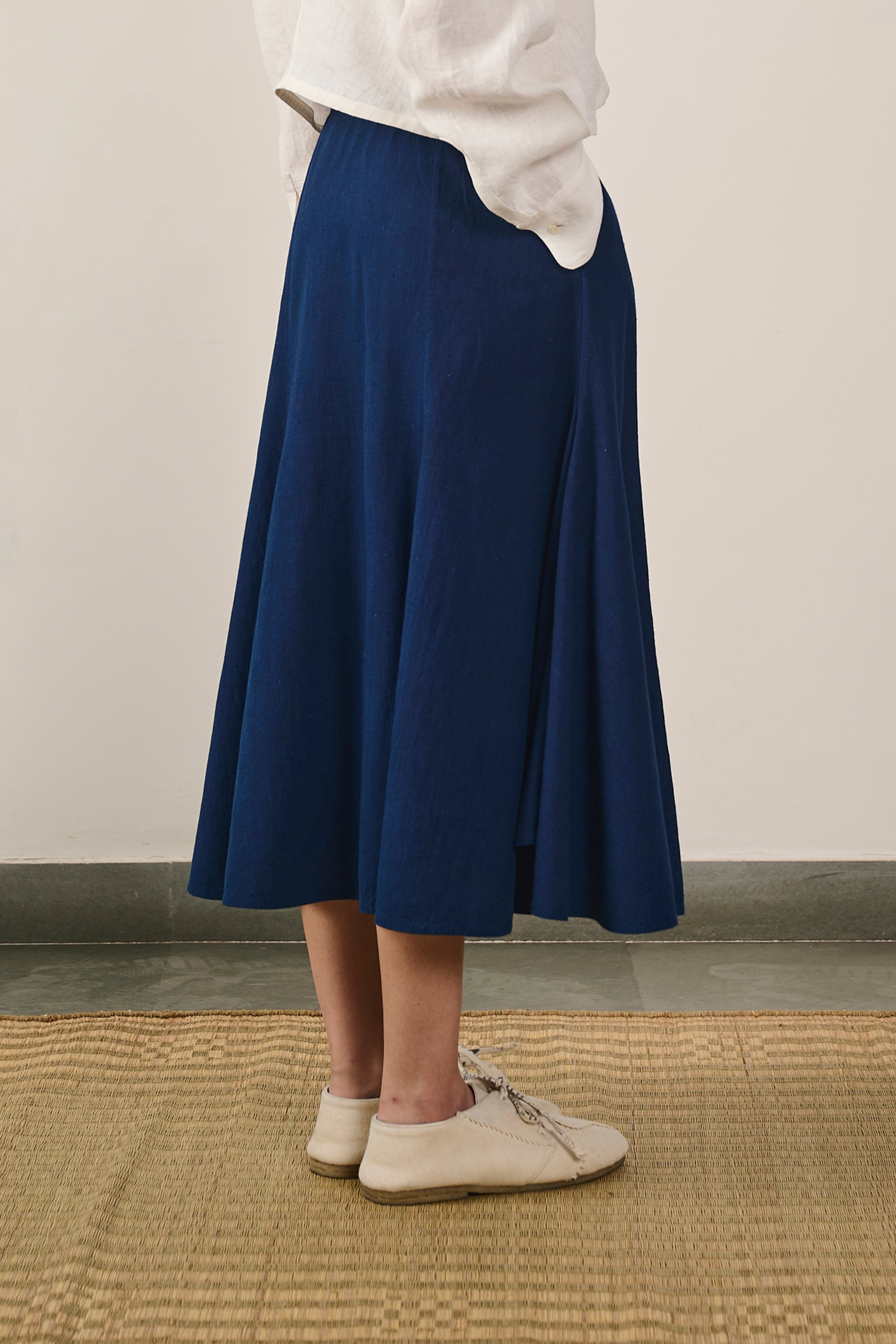 A side shot of a woman wearing indigo skirt
