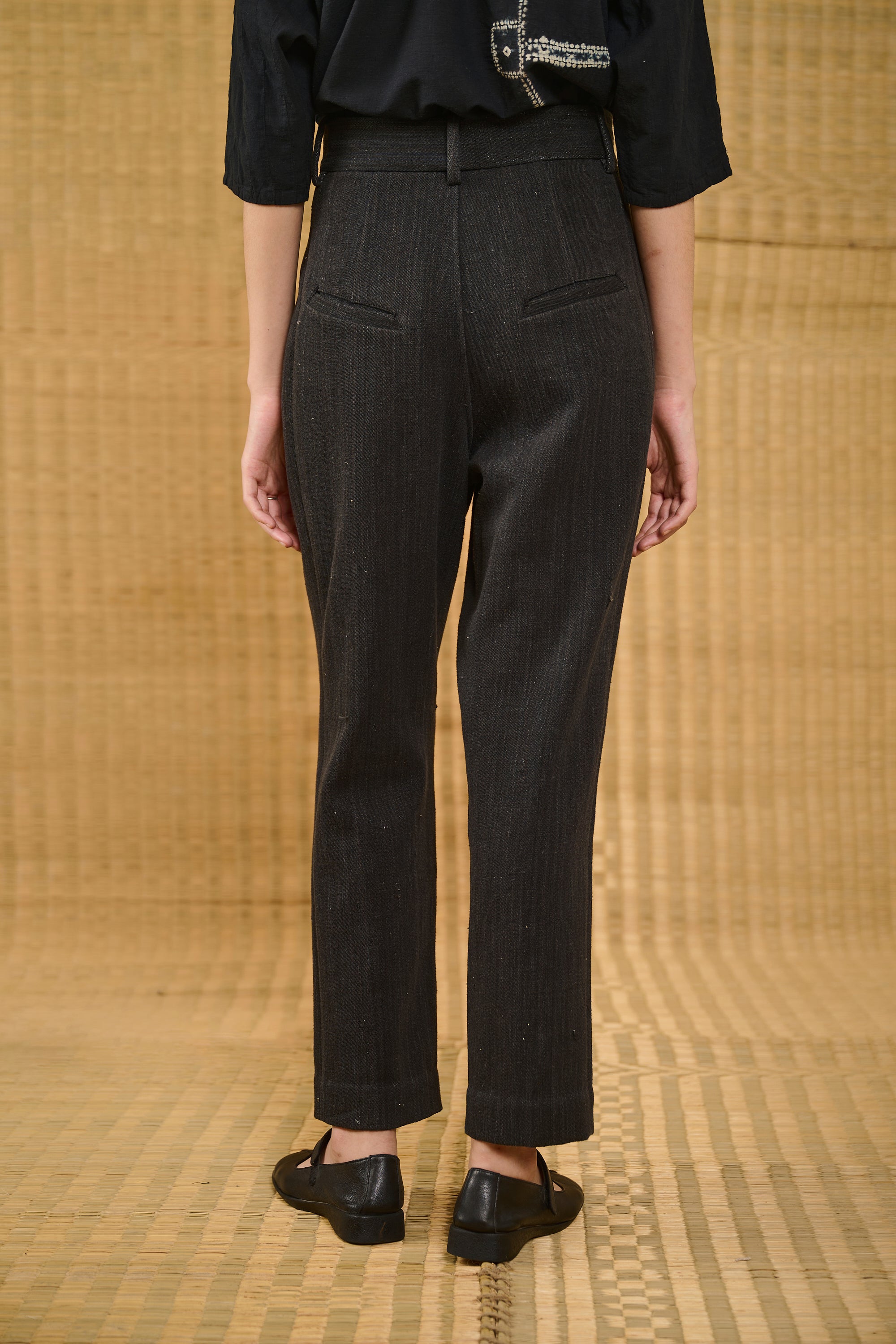 A back shot of a woman wearing medium indigo denim pant