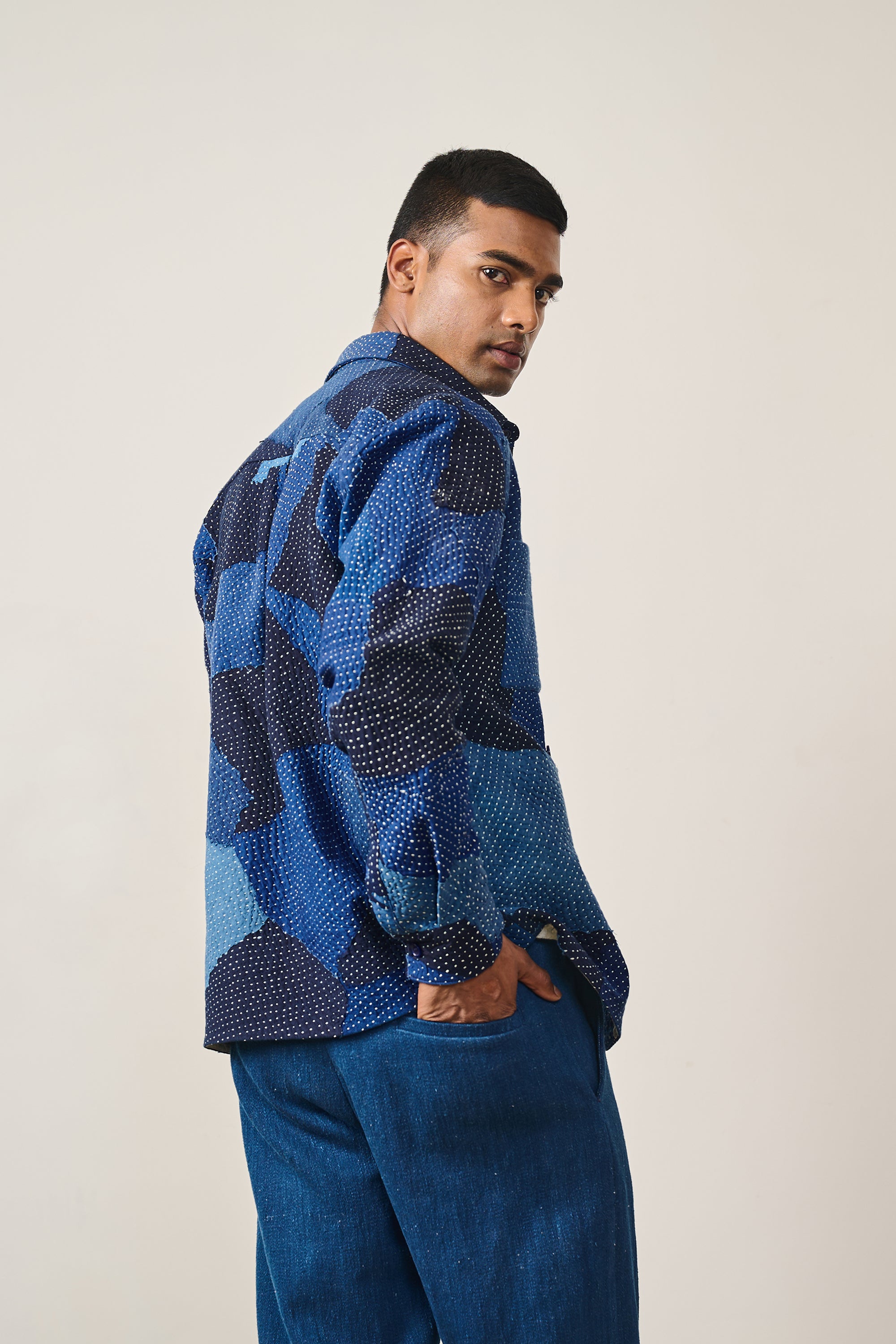A back shot of a man wearing indigo cotton patchwork shirt