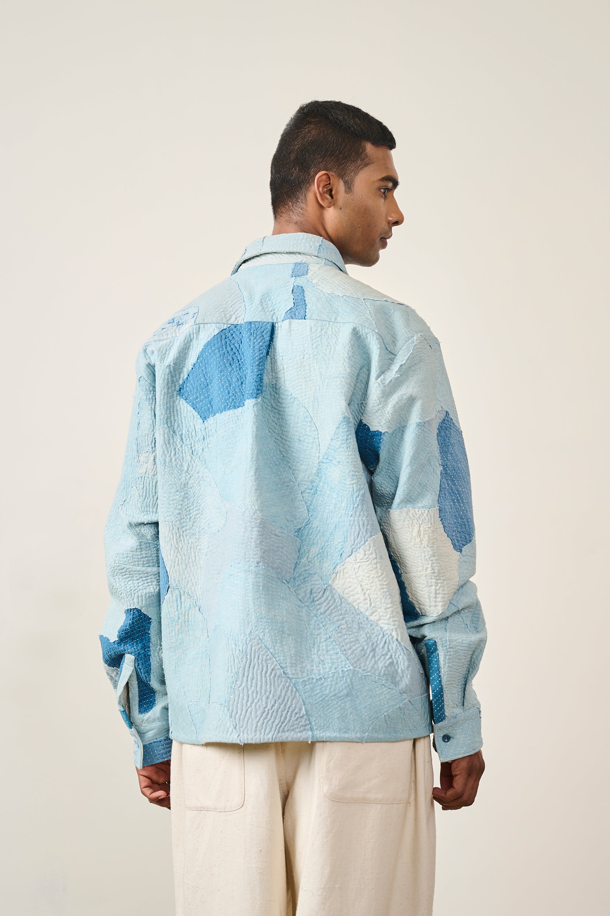 A back shot of a man wearing sky indigo cotton shirt with patchwork