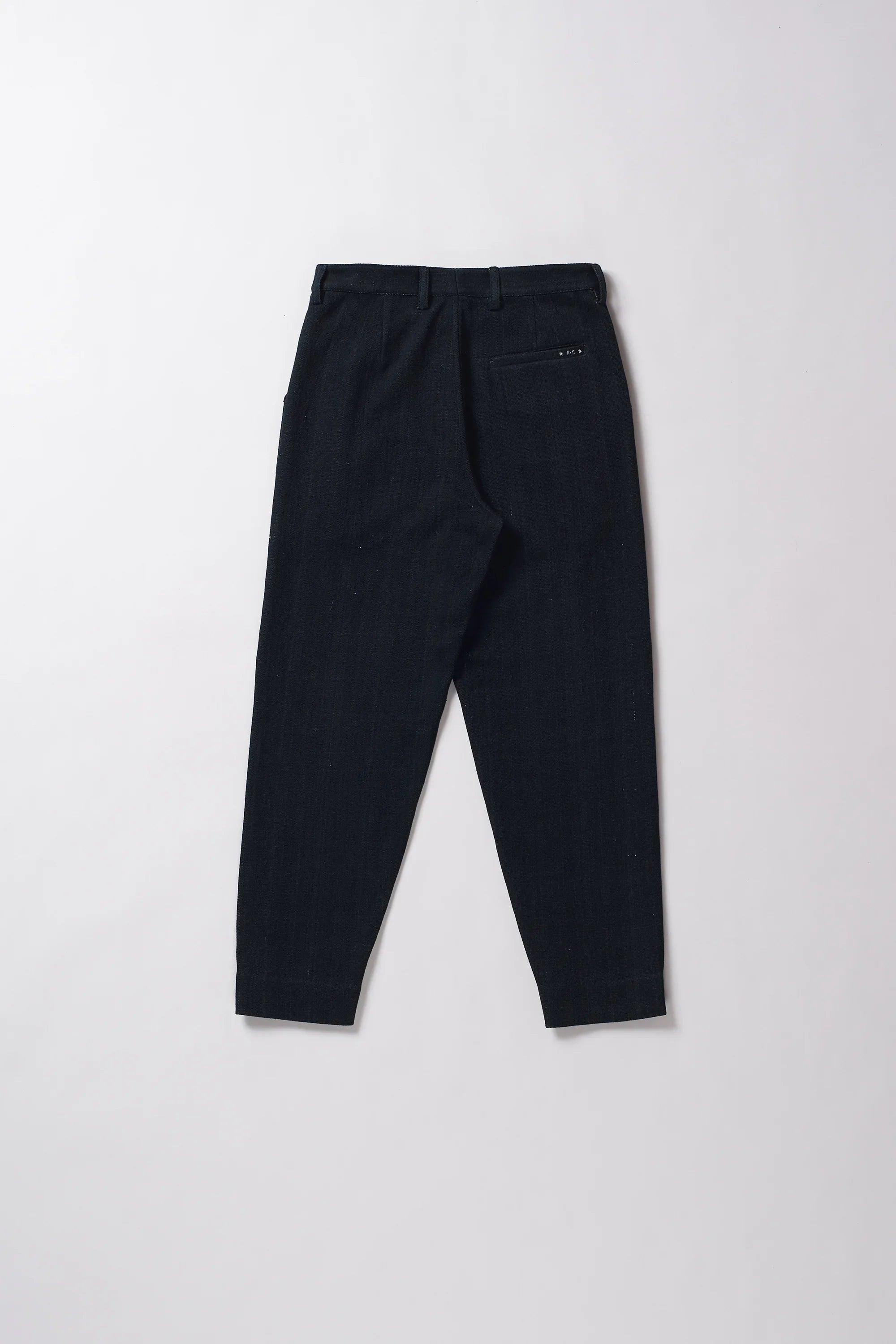 Back image of midnight indigo pants on a grey background