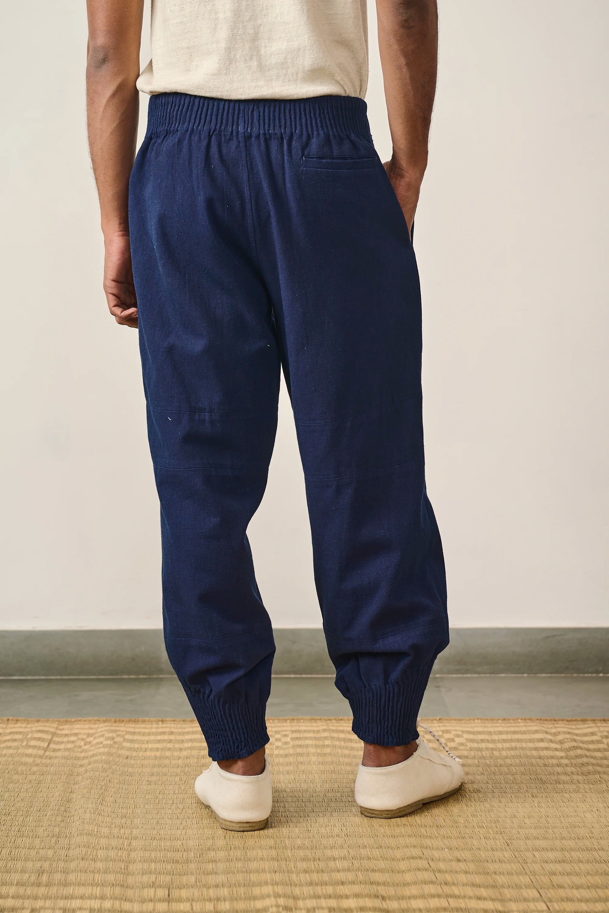 A back shot of a man wearing medium indigo pant