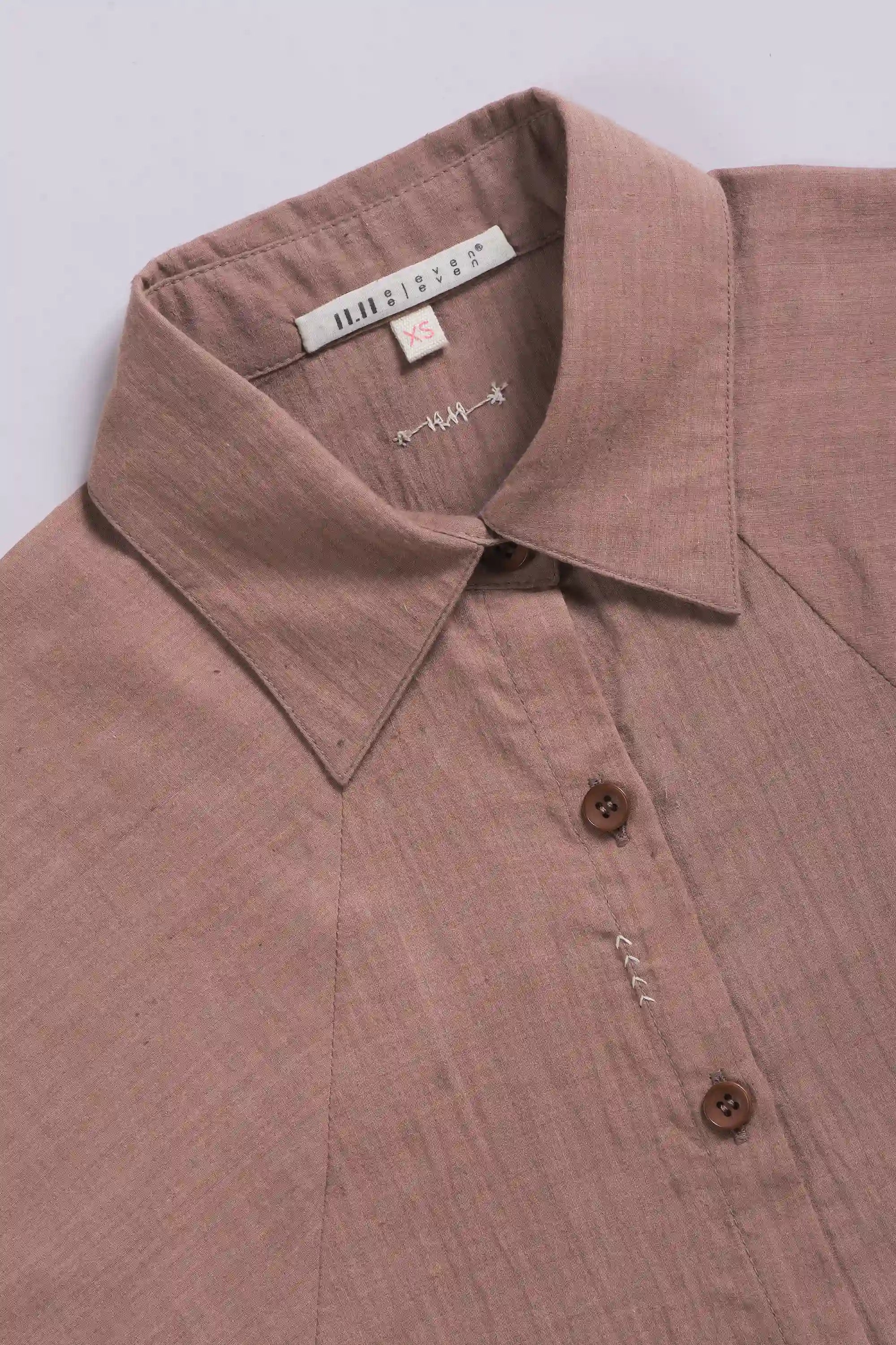 Close-up of a old rose shirt with a collar and buttons on a light grey background