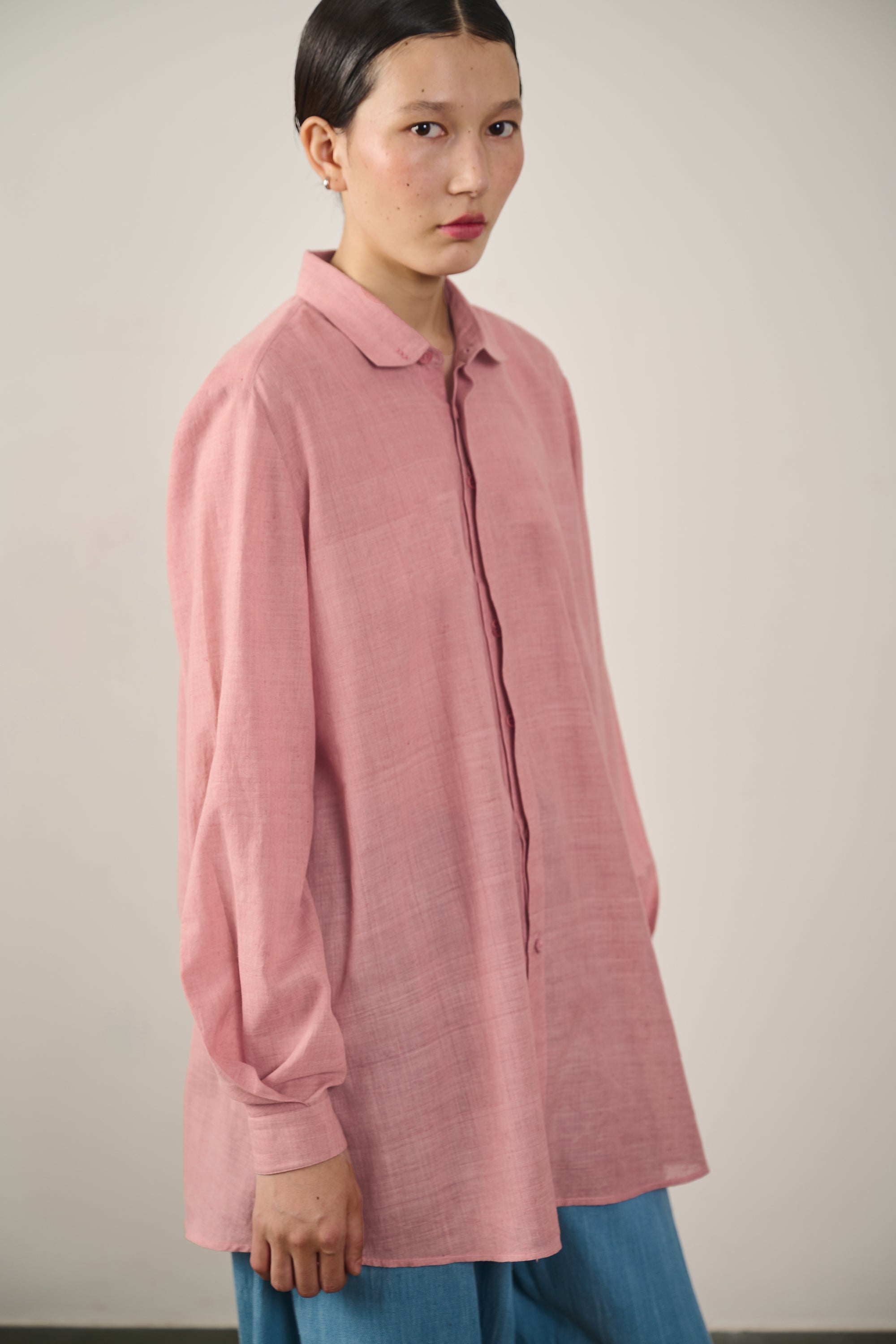 A woman wearing chalk pink cotton shirt