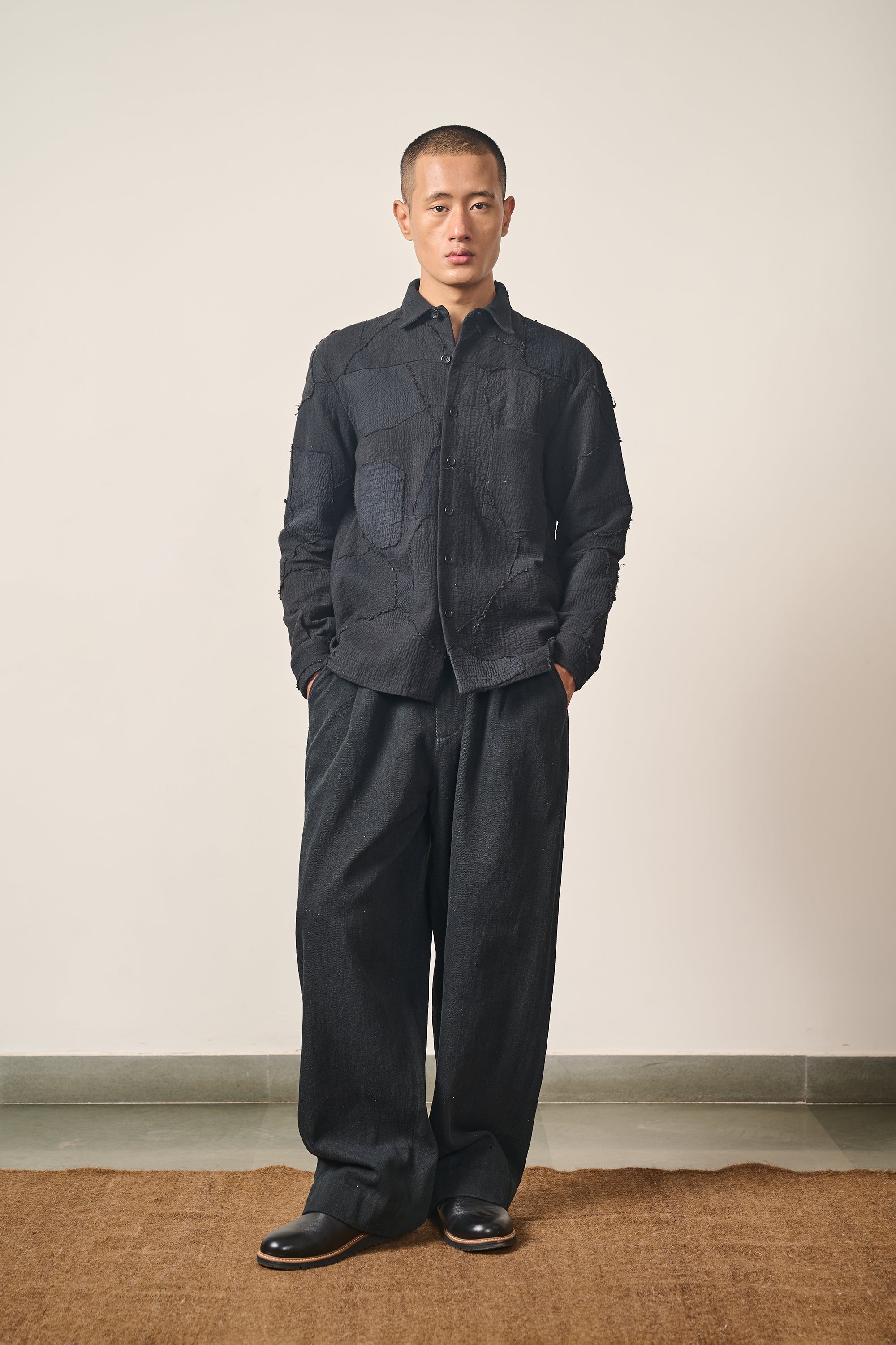 A man wearing black patchwork shirt