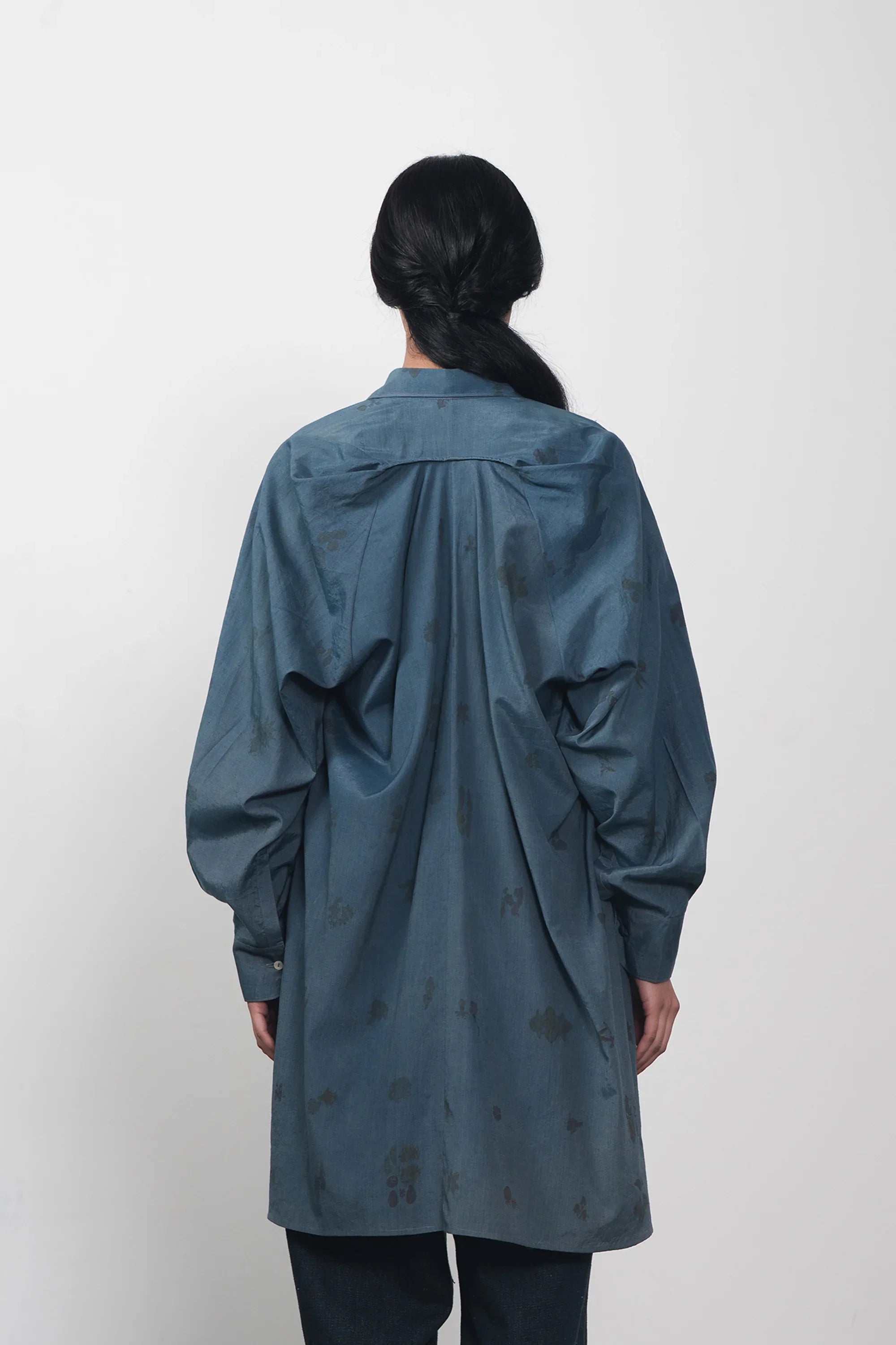 A back shot of a women wearing estate blue shirt