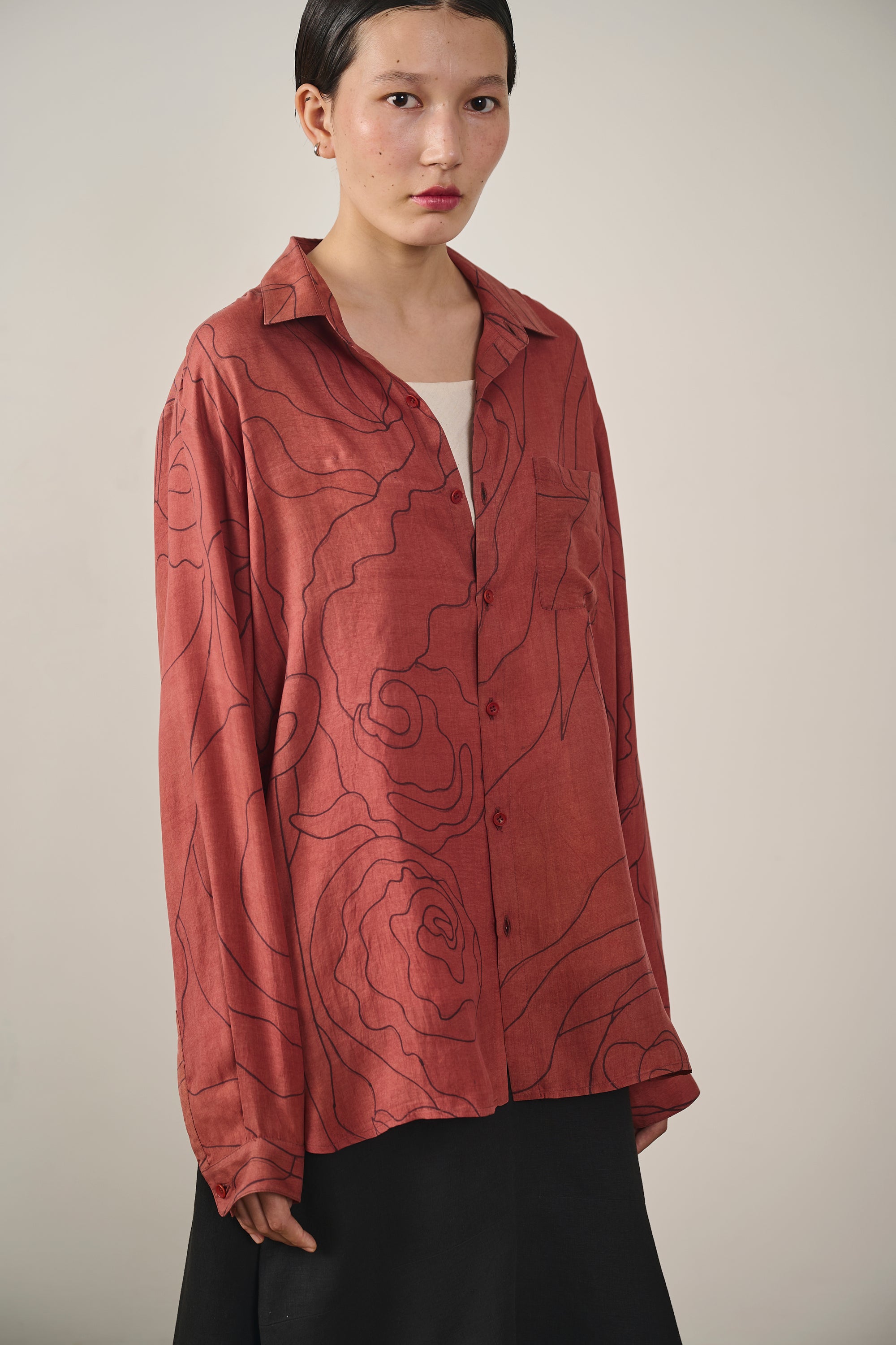 A woman wearing rouge pink silk shirt