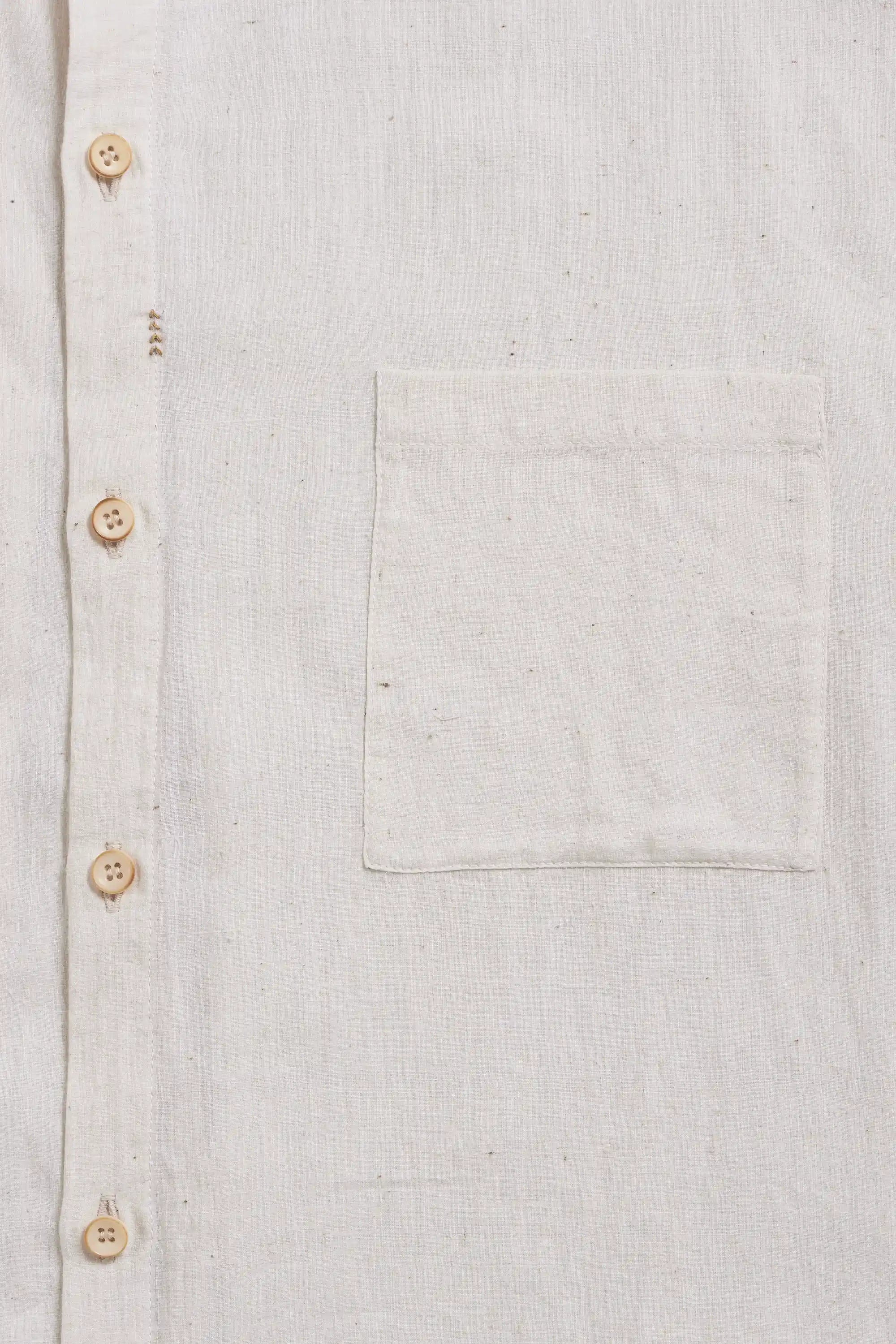 Close-up of a shirt with button details and a pocket.