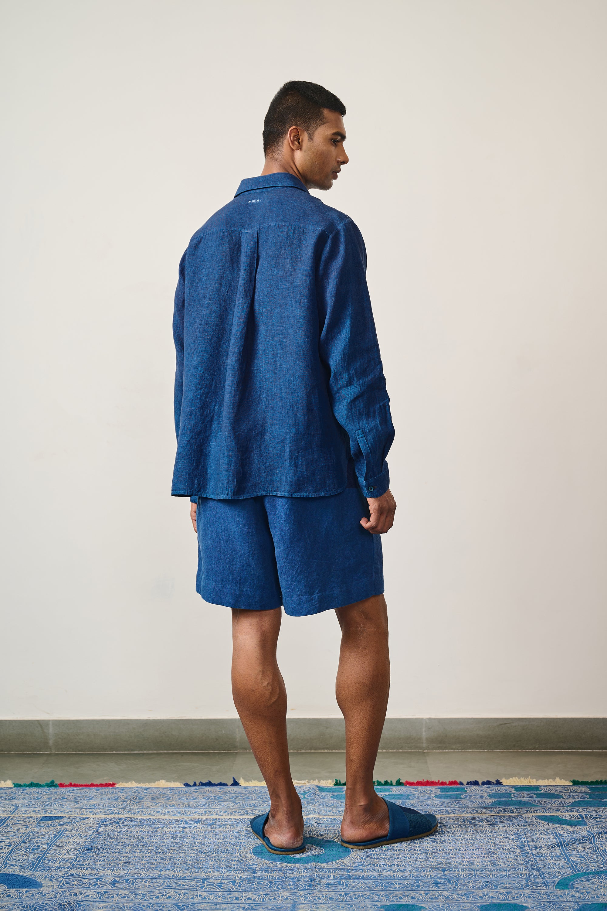 A back shot of man wearing medium medium indigo shirt