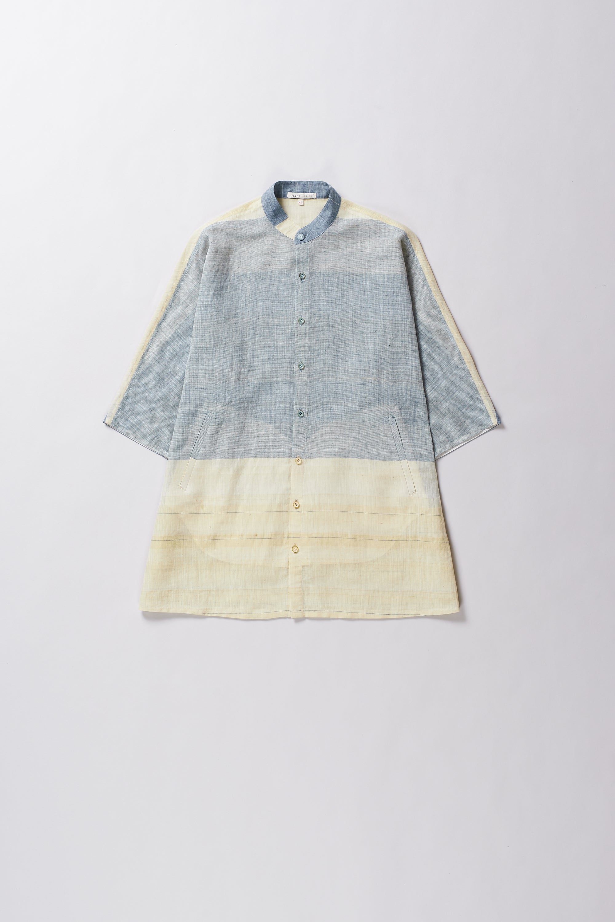 Two-tone shirt with blue and beige sections on a light grey background