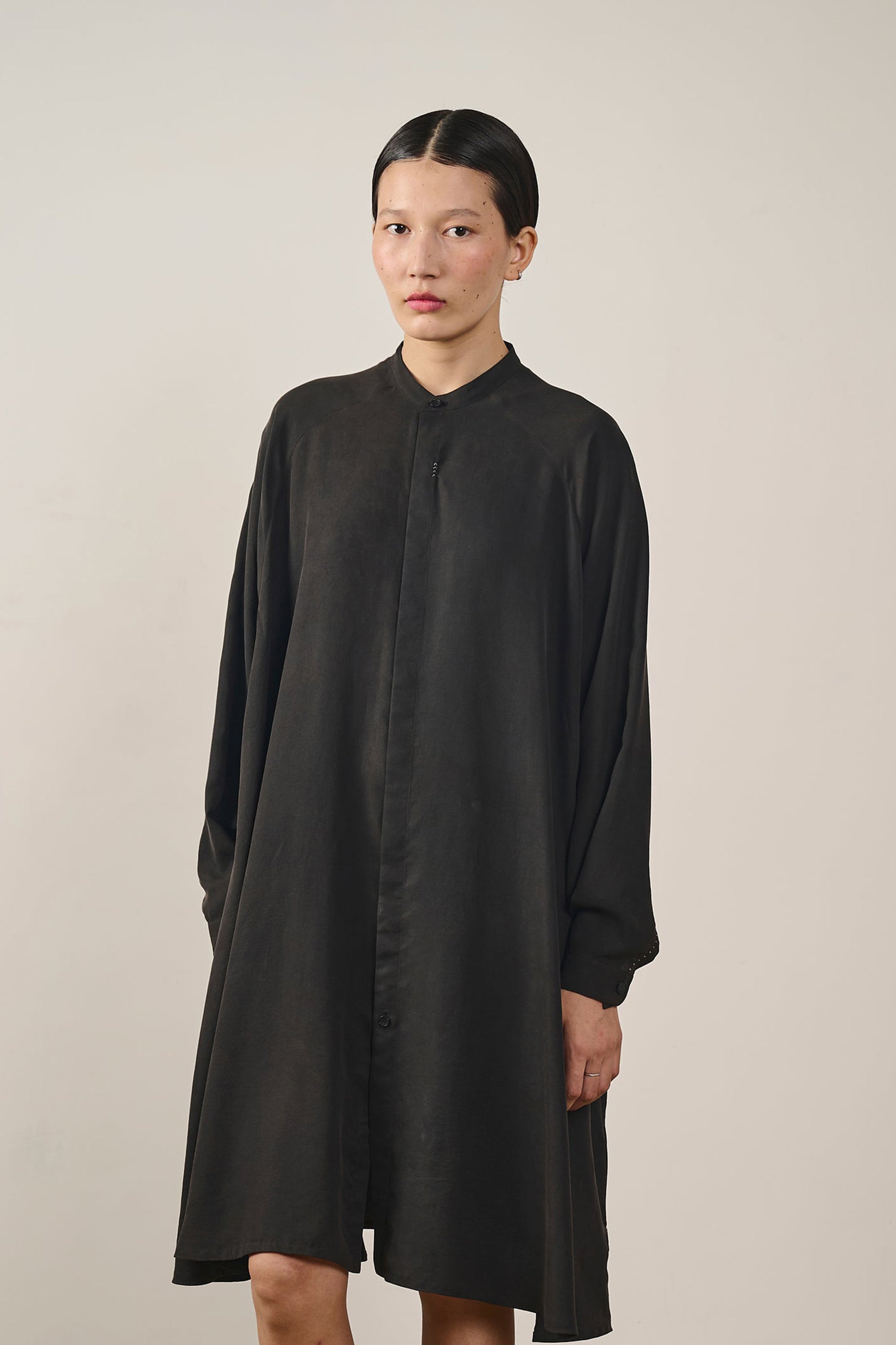 A woman wearing silk black dress