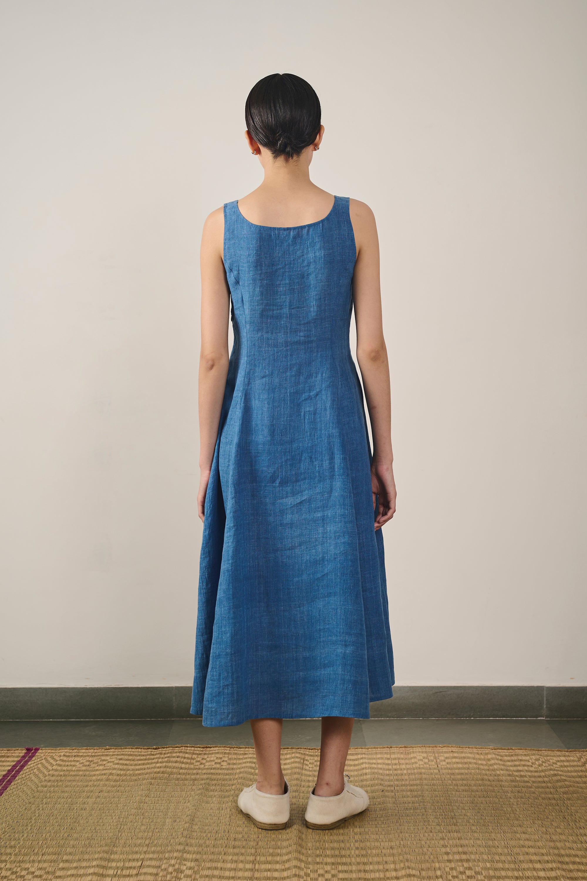 A back shot of a woman wearing medium indigo dress