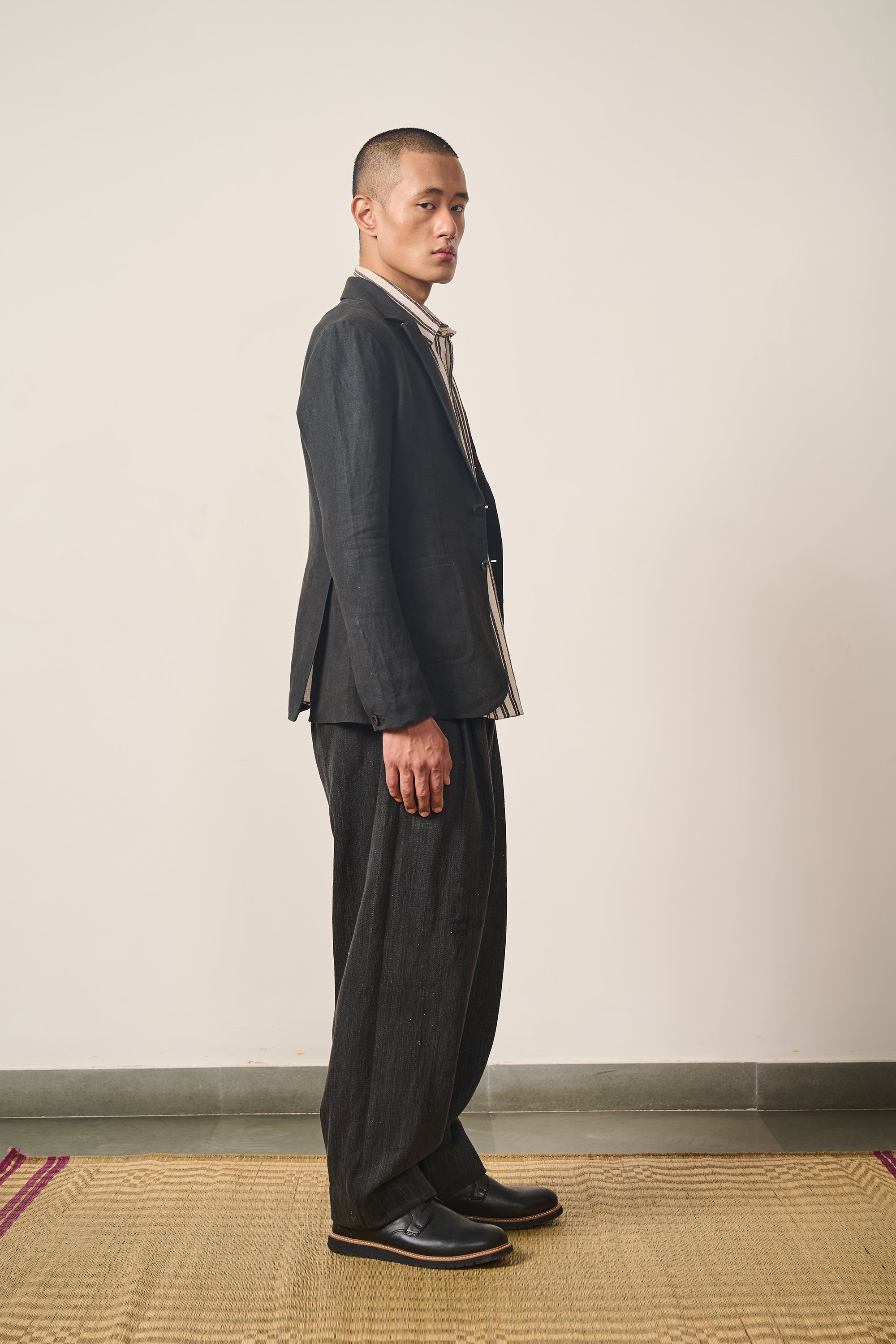 A side shot of a man wearing linen black jacket