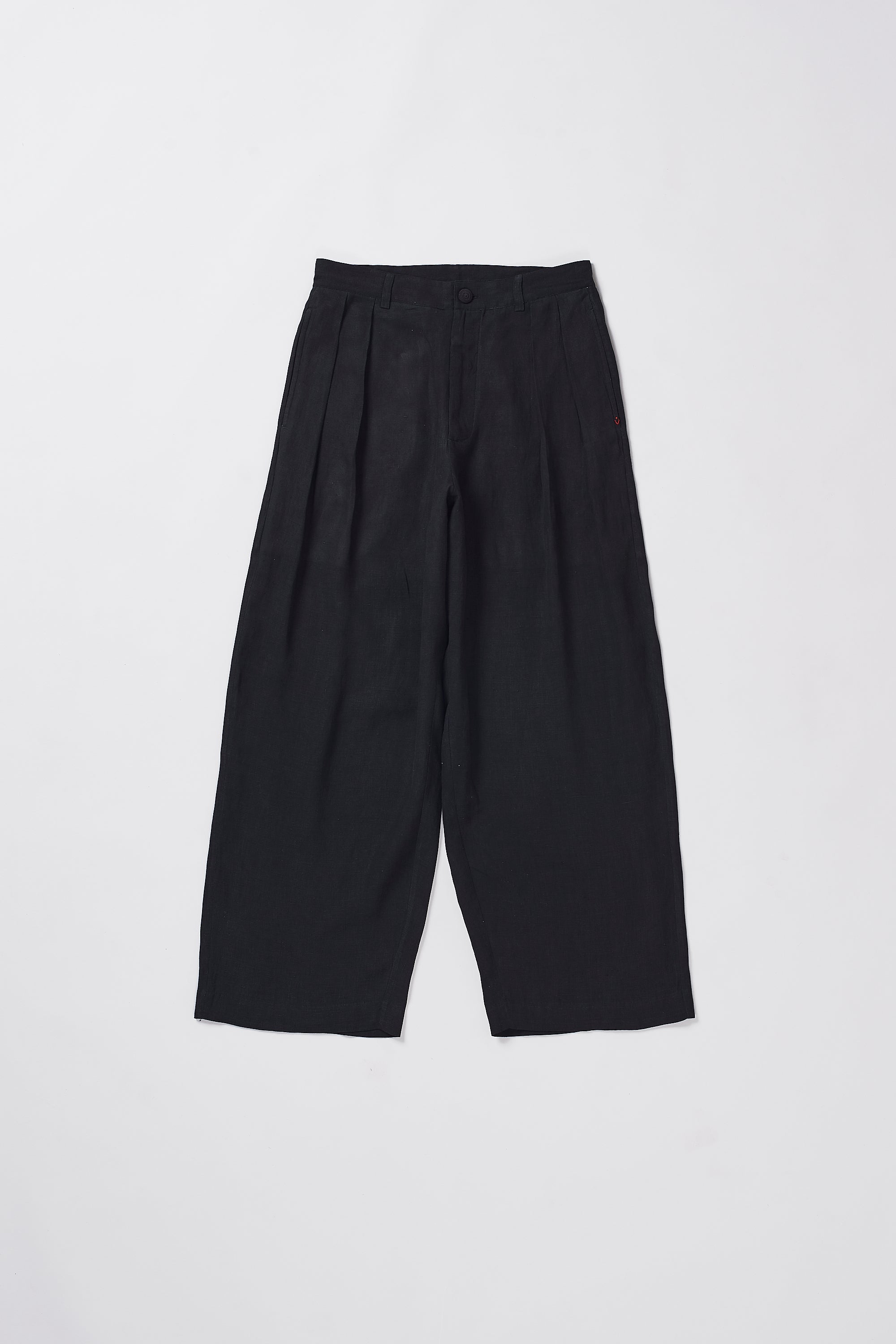 Black pleated pants on a grey background
