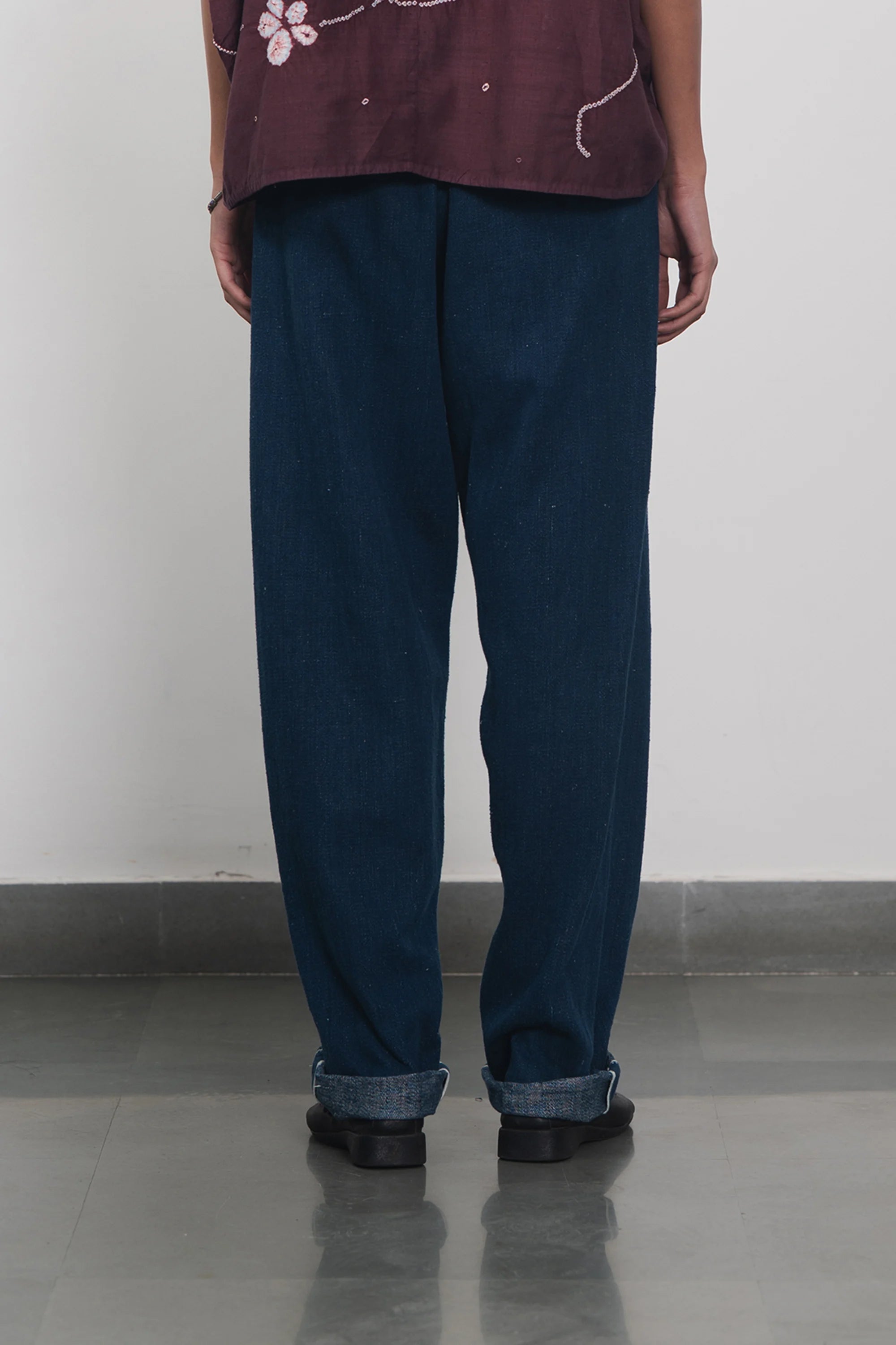 A back shot of a man wearing indigo pant