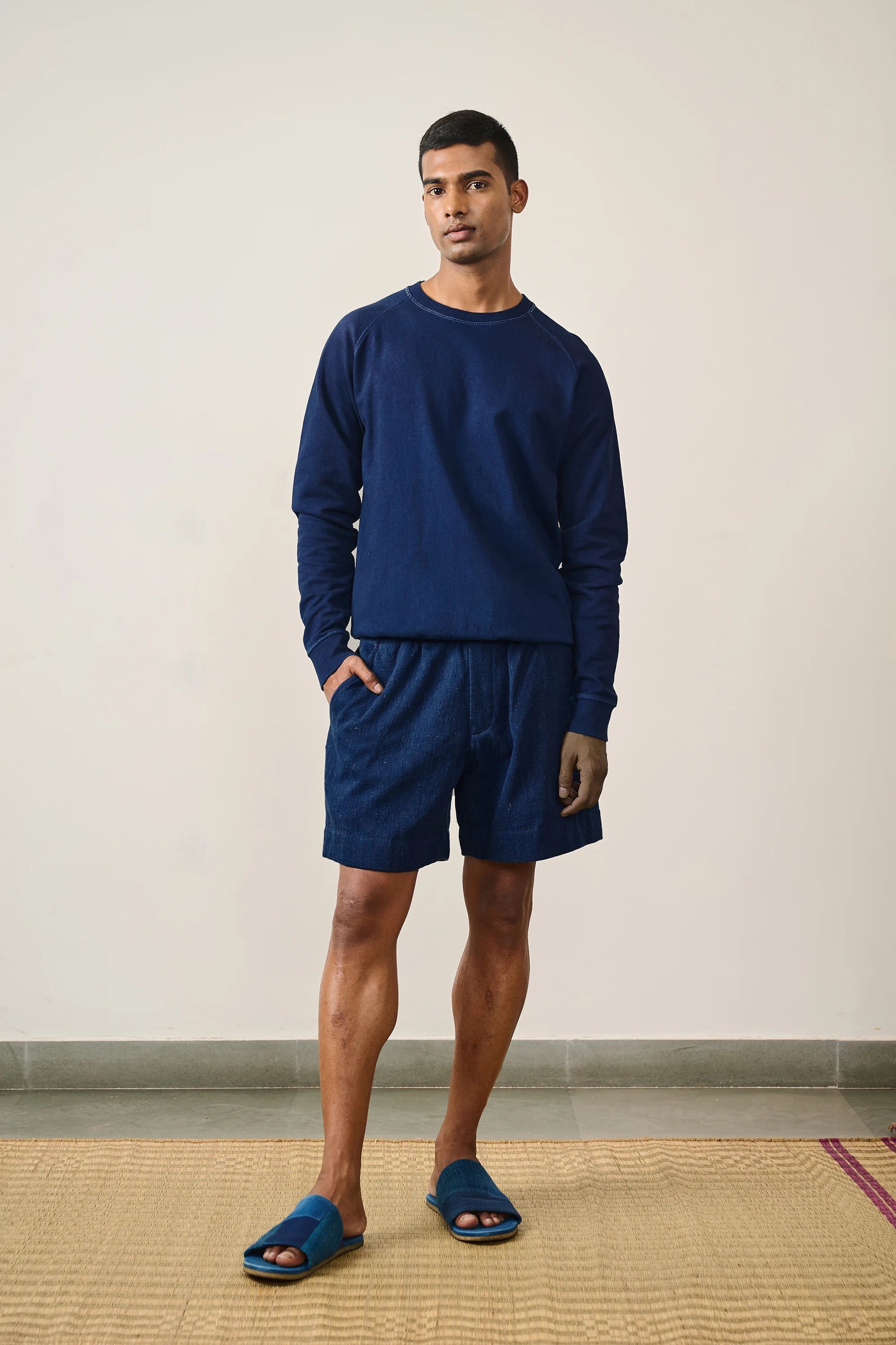A man wearing indigo sweatshirt