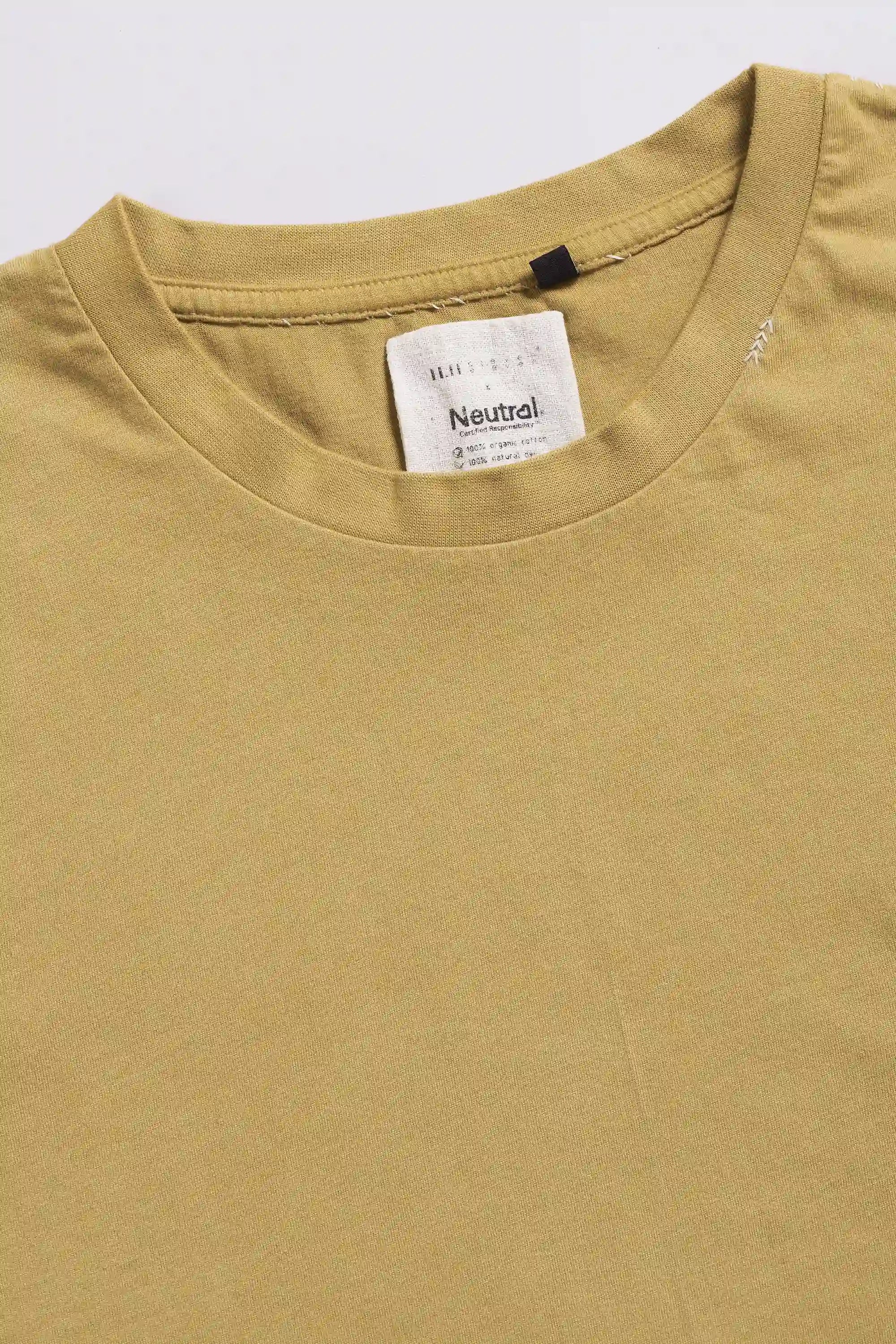 Close-up of a t-shirt with brand label on a light grey background