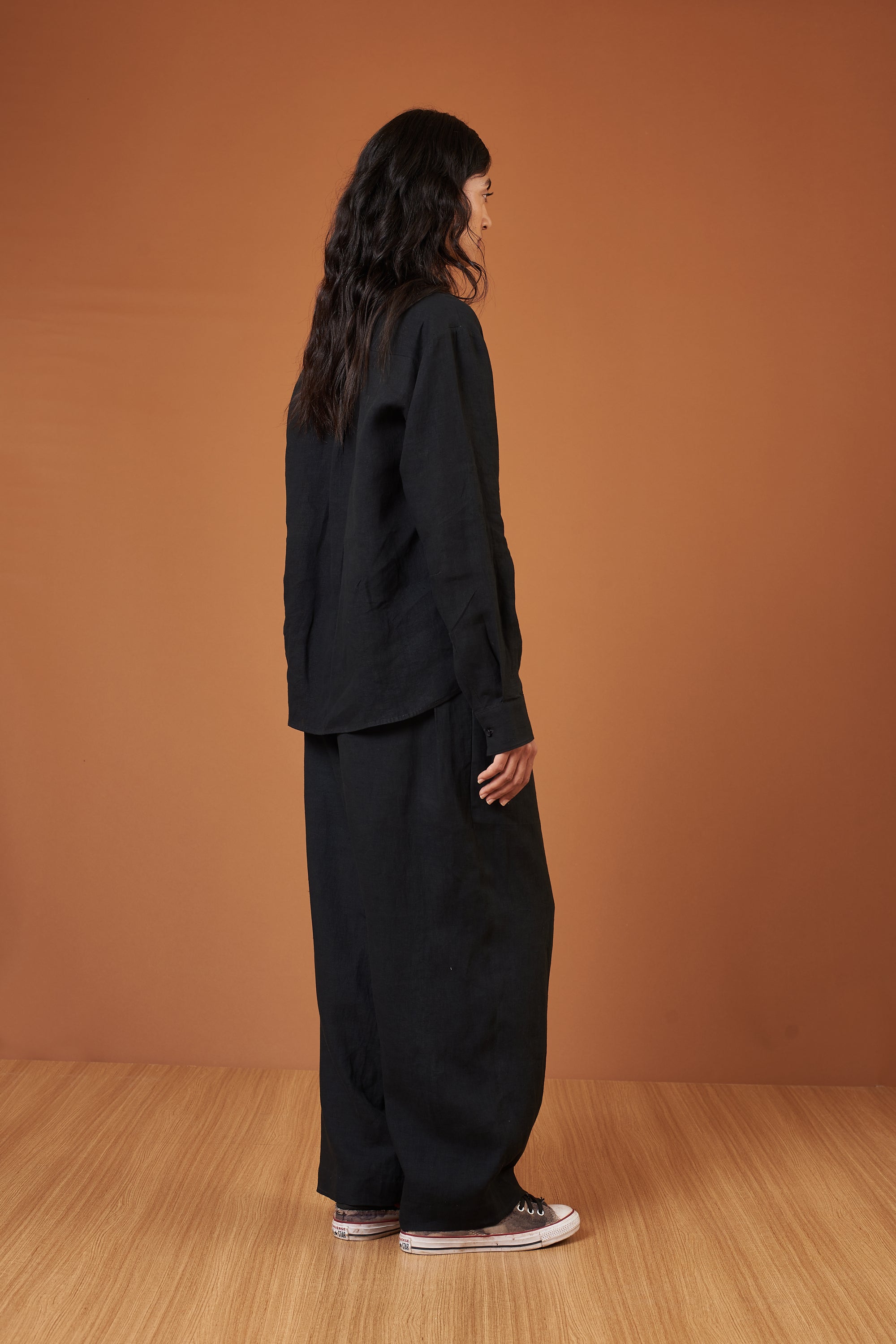 A back shot of a women wearing black linen shirt