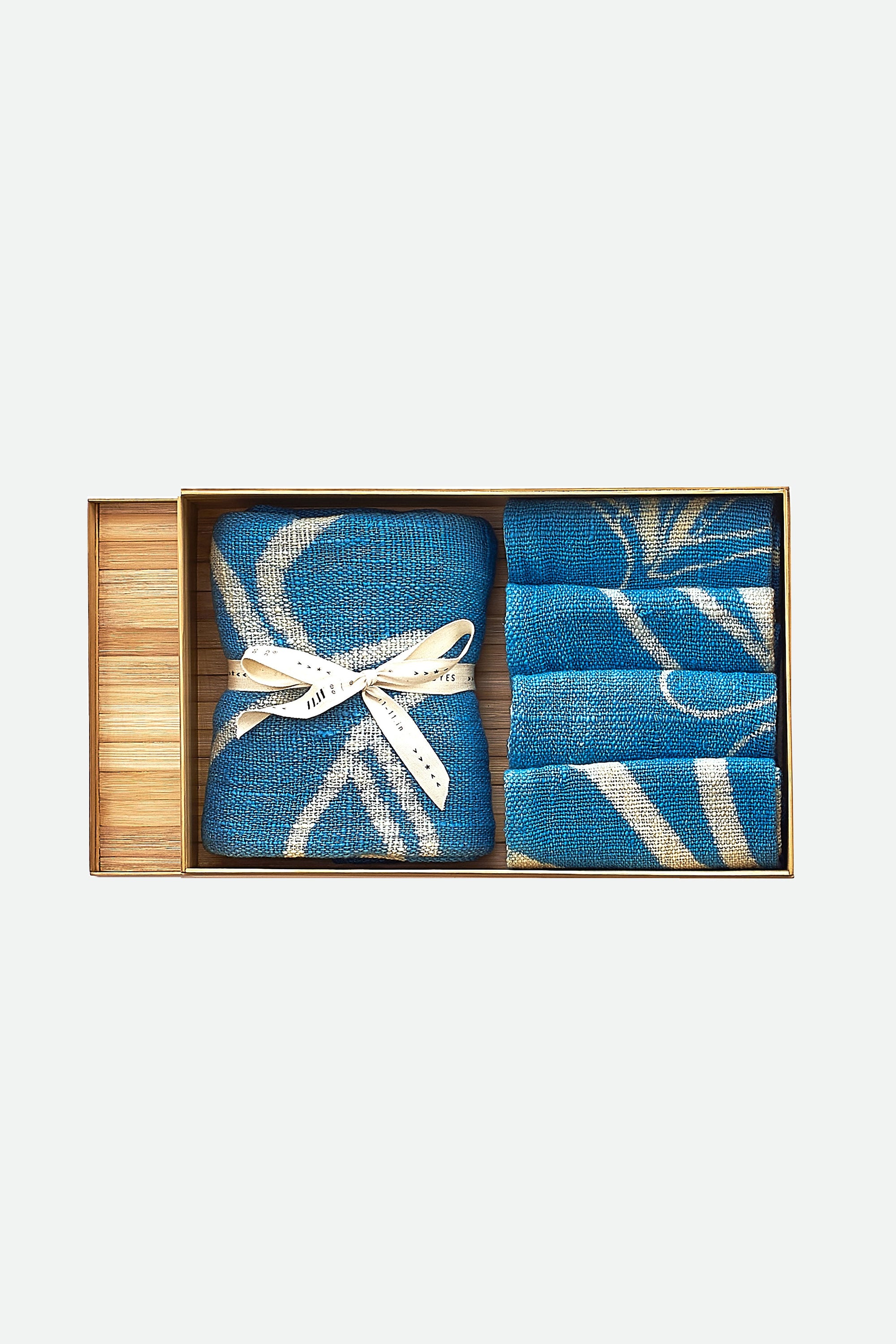A set of hand painted medium indigo striped towels presented in a bamboo box with a white ribbon.