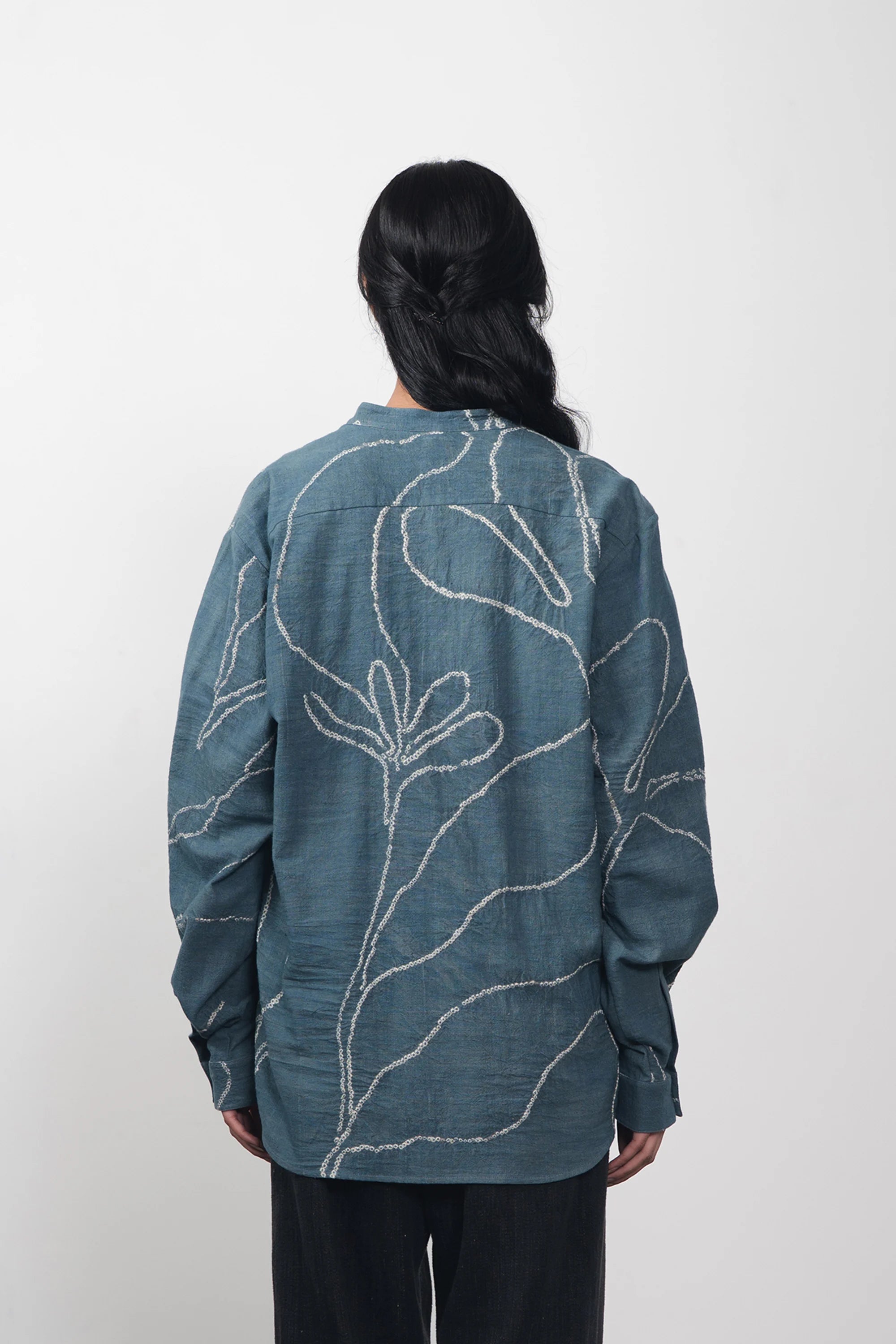 A back shot of a woman wearing ash indigo shirt