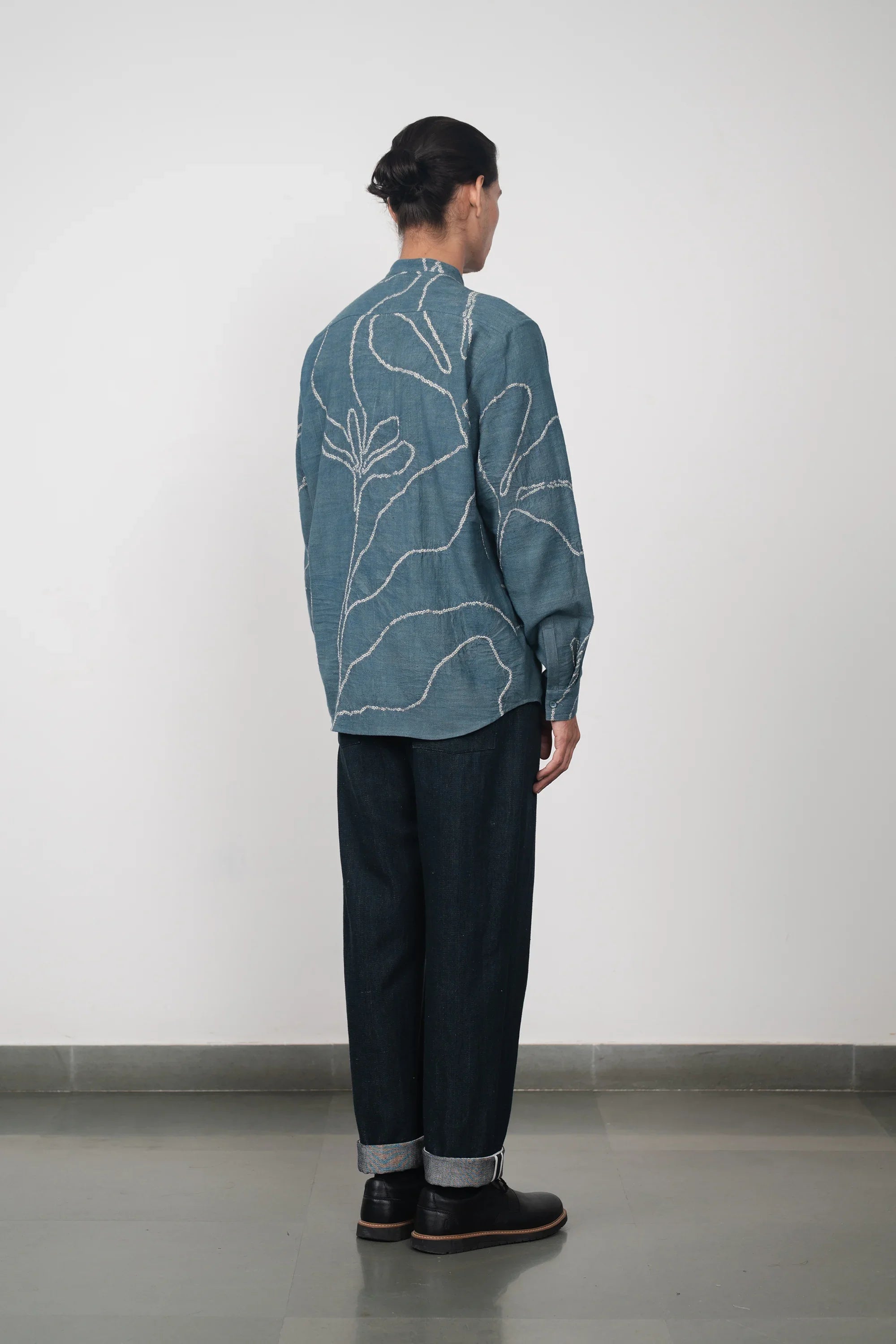 A back shot of a woman wearing ash indigo shirt
