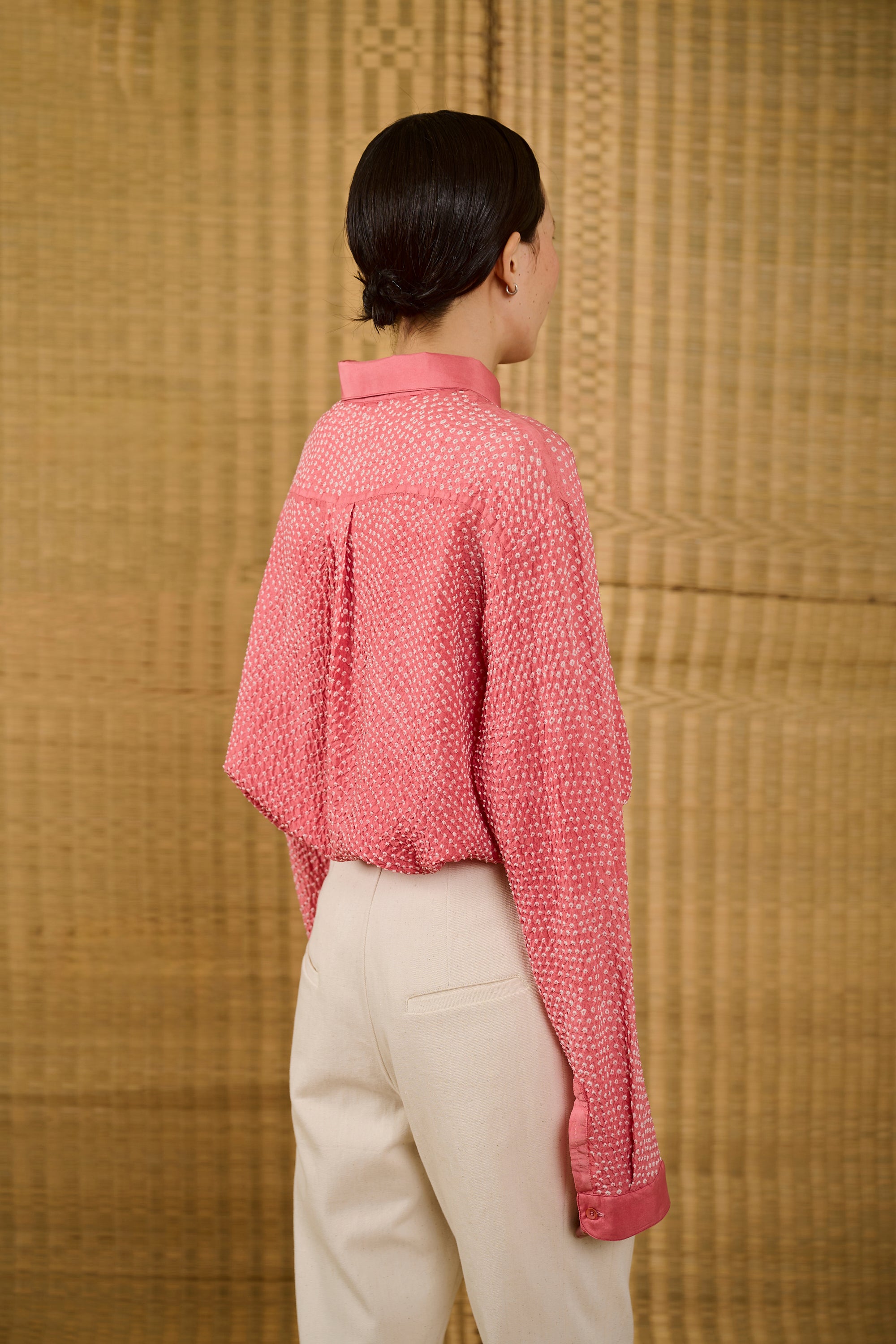 A back shot of a woman wearing pink wood shirt