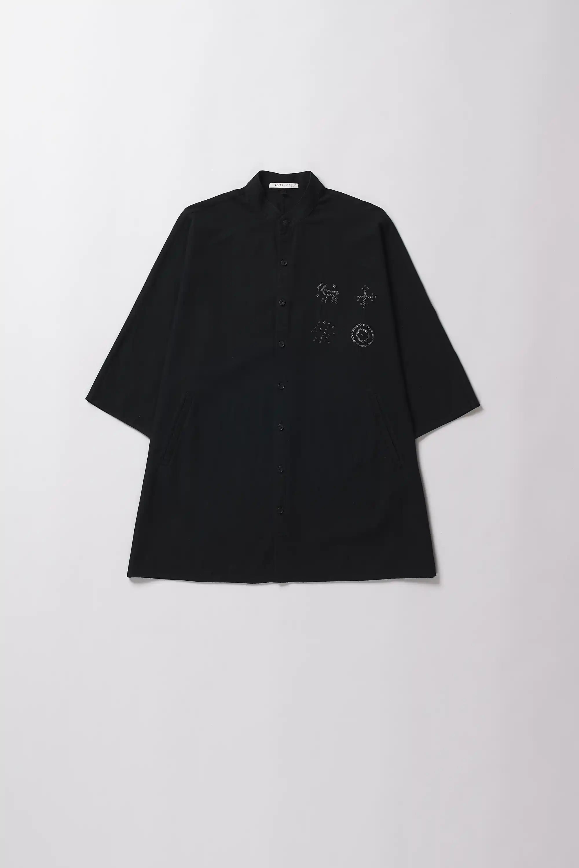 Black shirt with bandhani designs on a white background