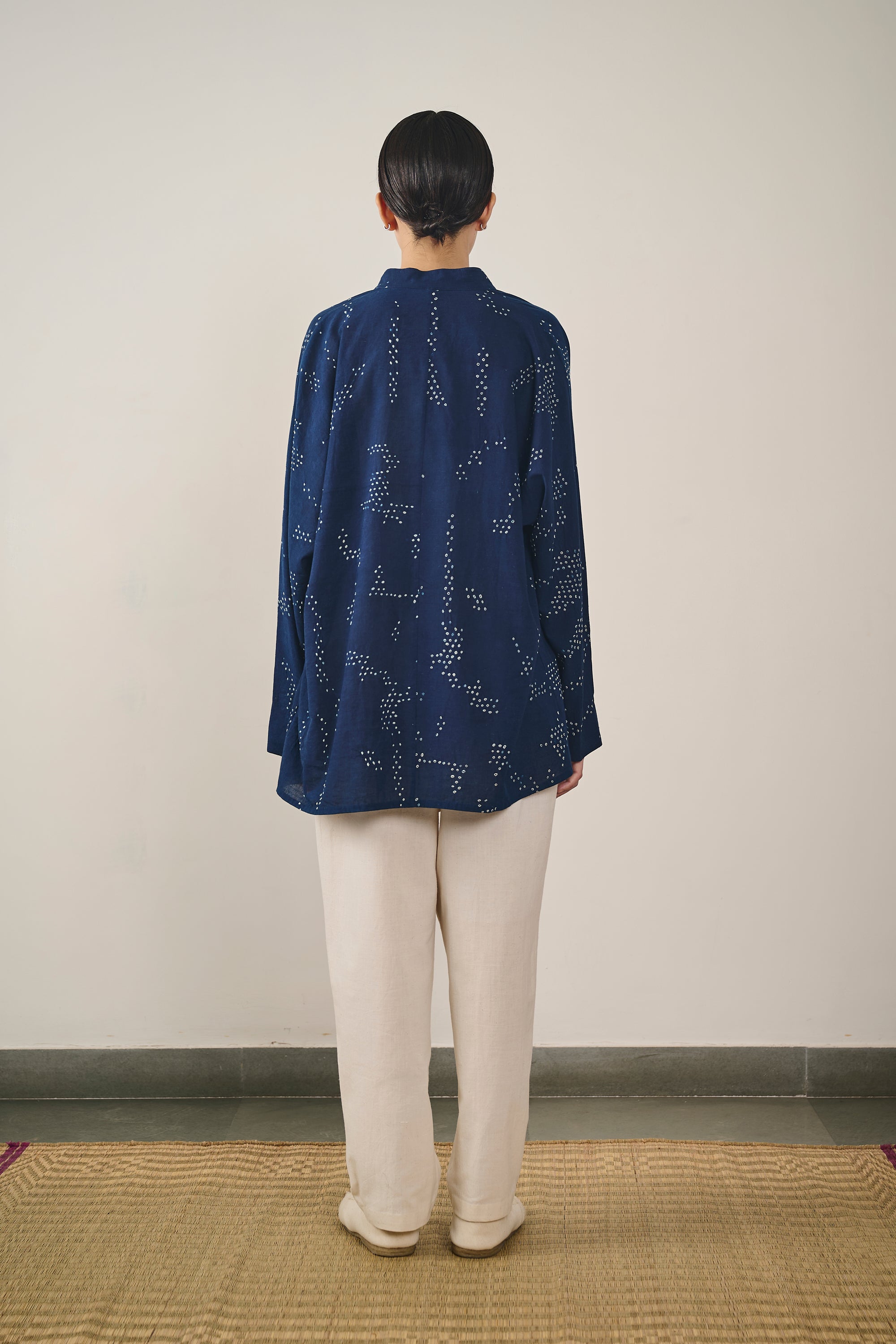 A back shot of a woman wearing indigo bandhani shirt