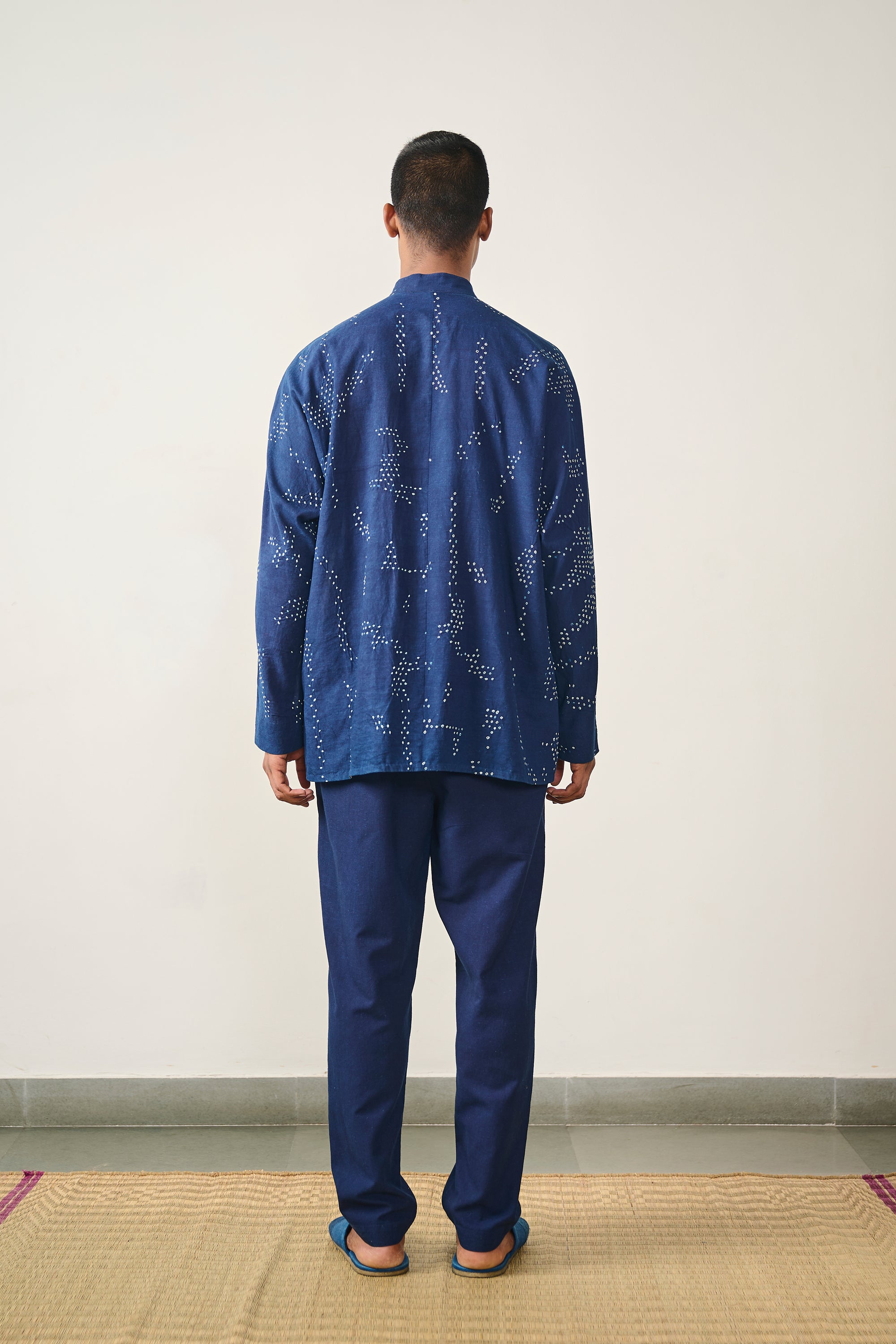 A back shot of a man wearing indigo cotton shirt