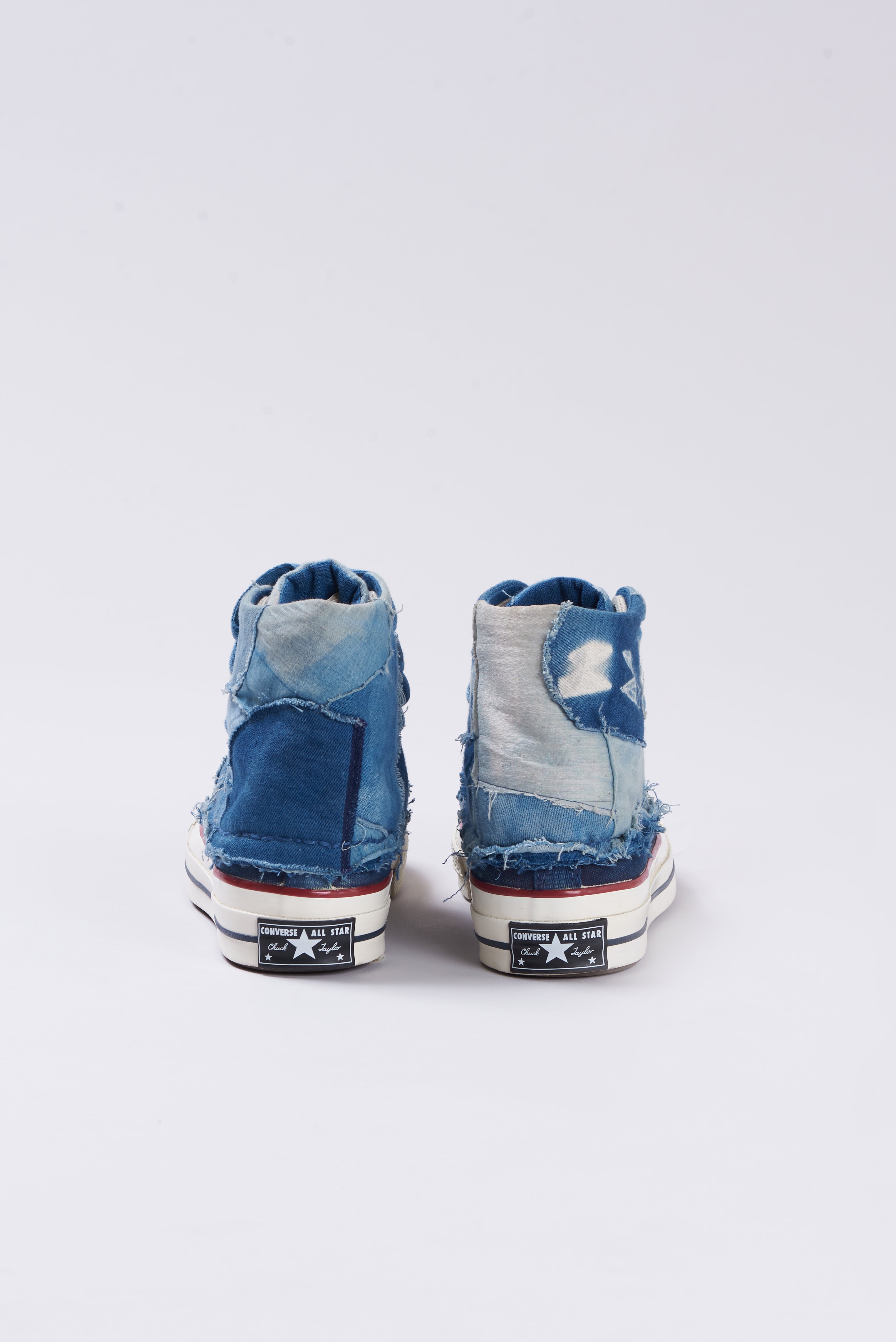 A back shot of a pair of blue high-top sneakers