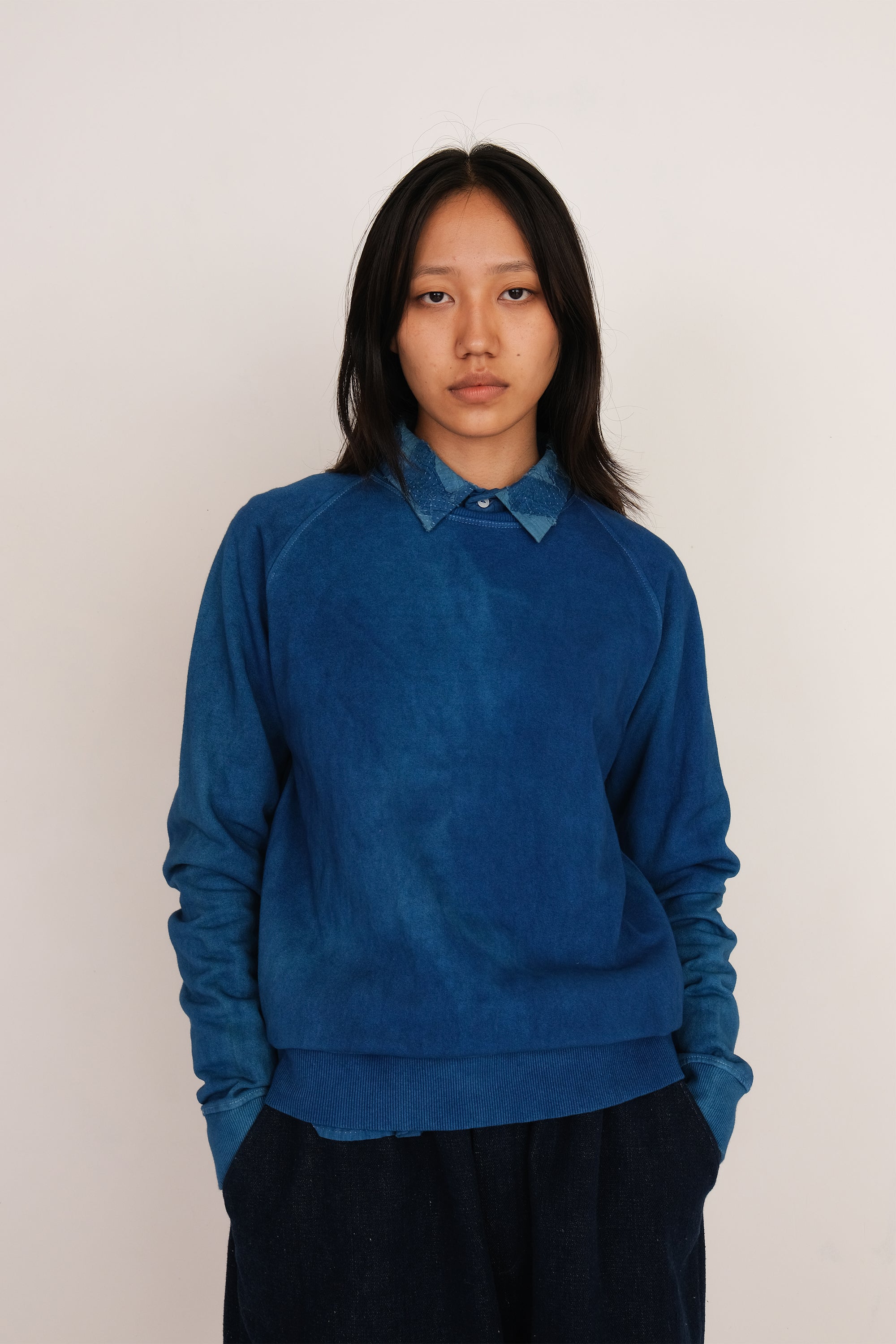 A woman wearing medium indigo sweatshirt