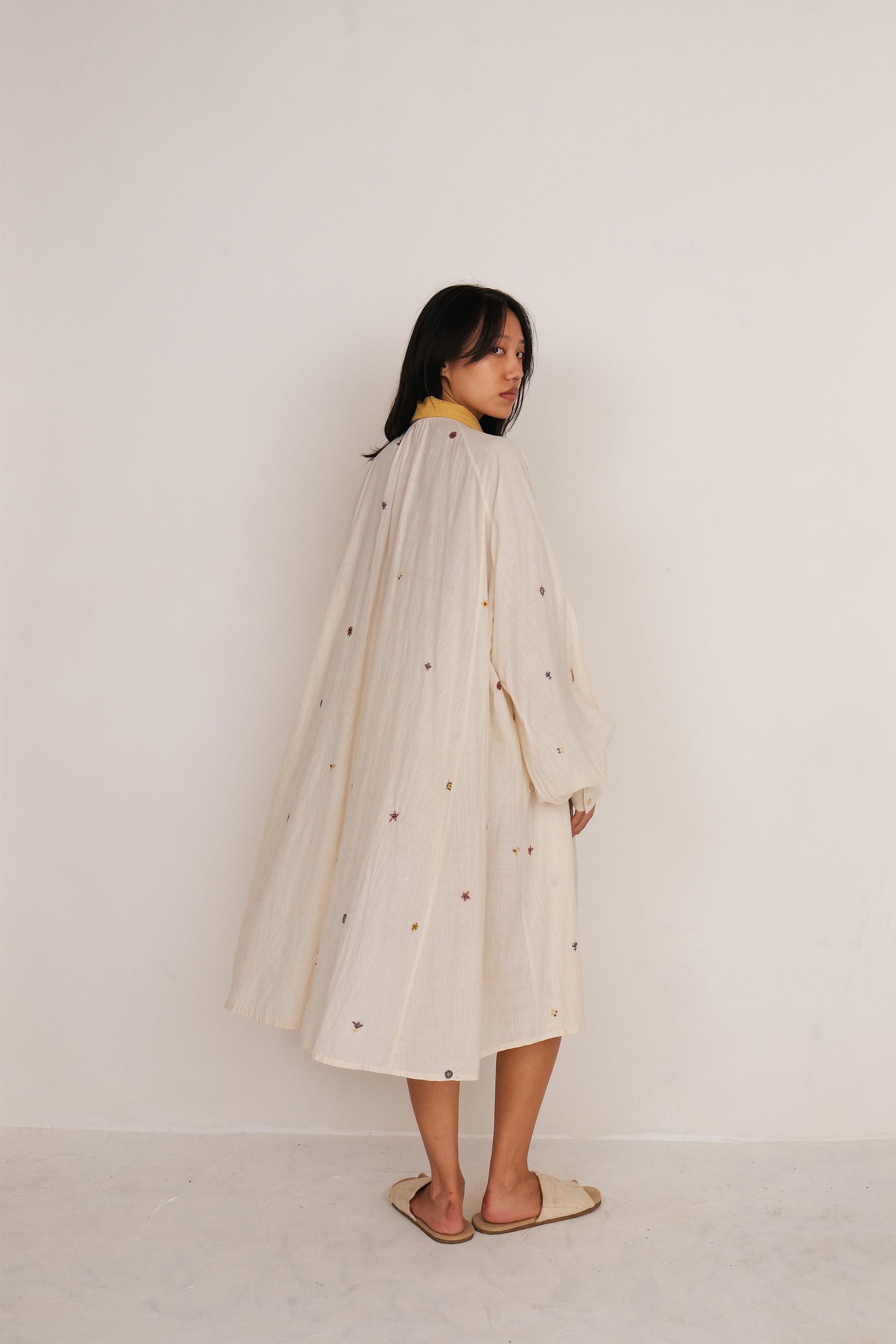 A back shot of a woman wearing ecru dress