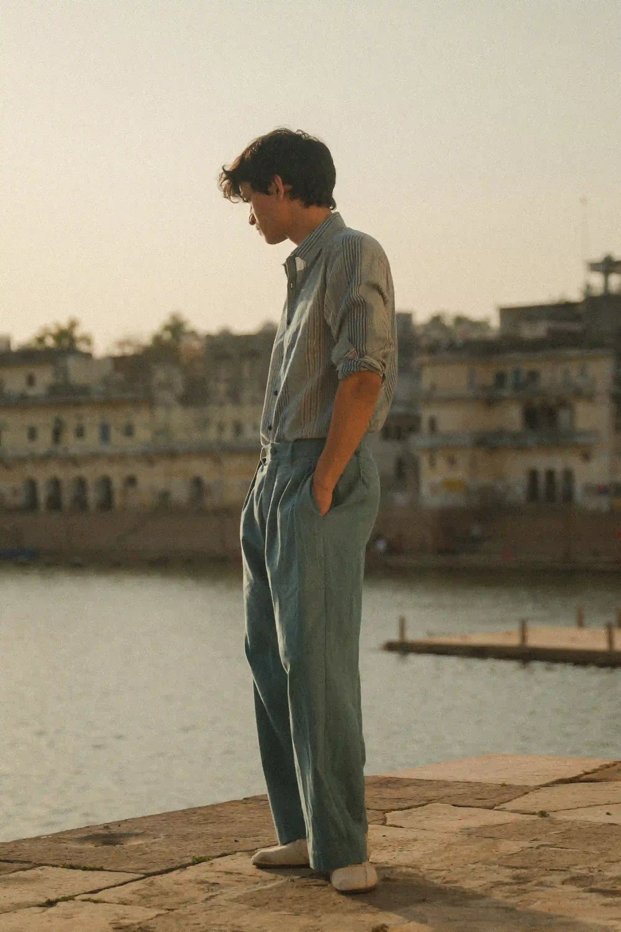 A side shot of a man wearing powder blue pant and light blue shirt