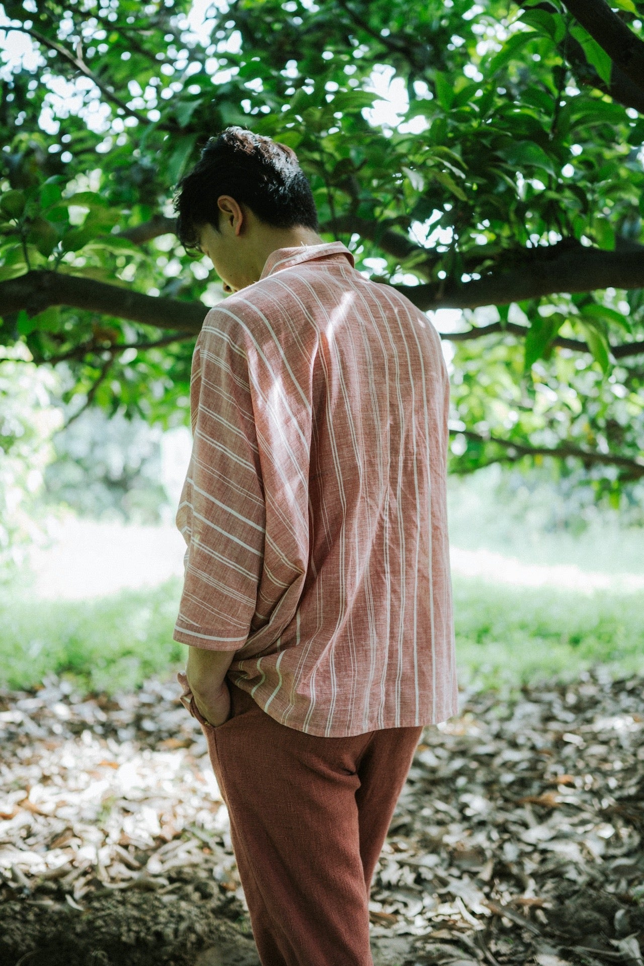 A back shot of a man wearing red cotton shirt