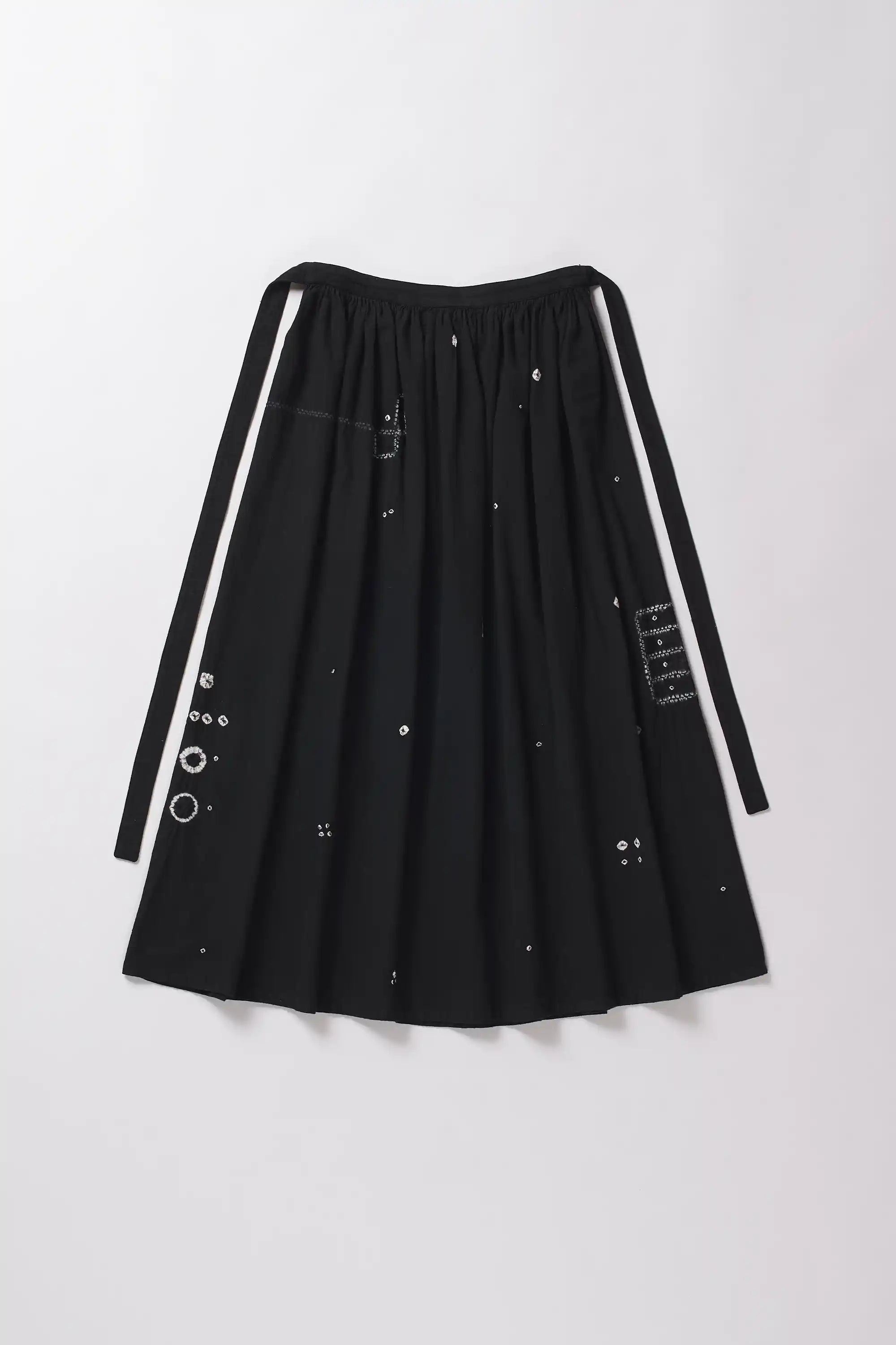 Back image of black skirt with white Shibori accents on a grey background