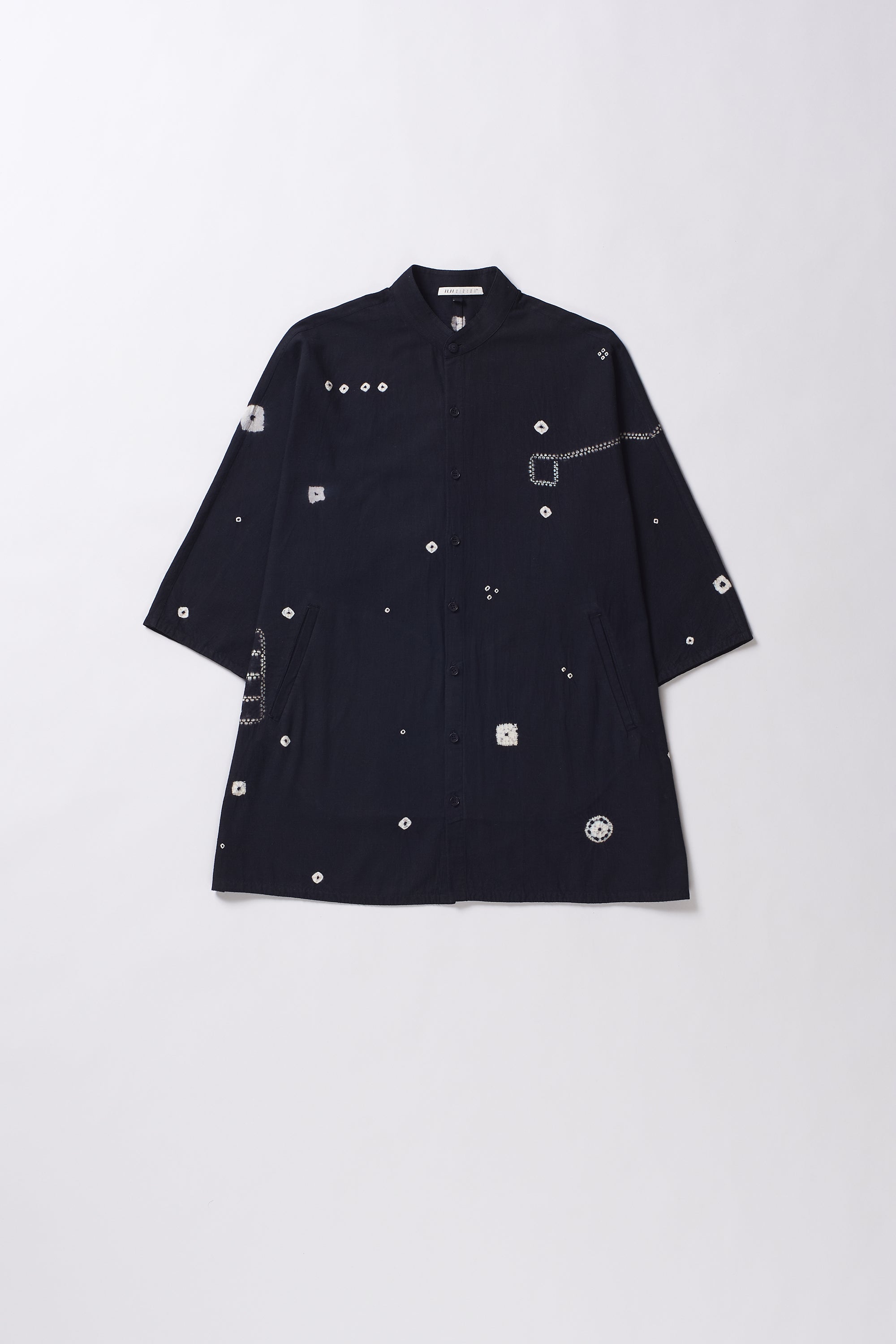 Black shirt with white buttons on a light grey background