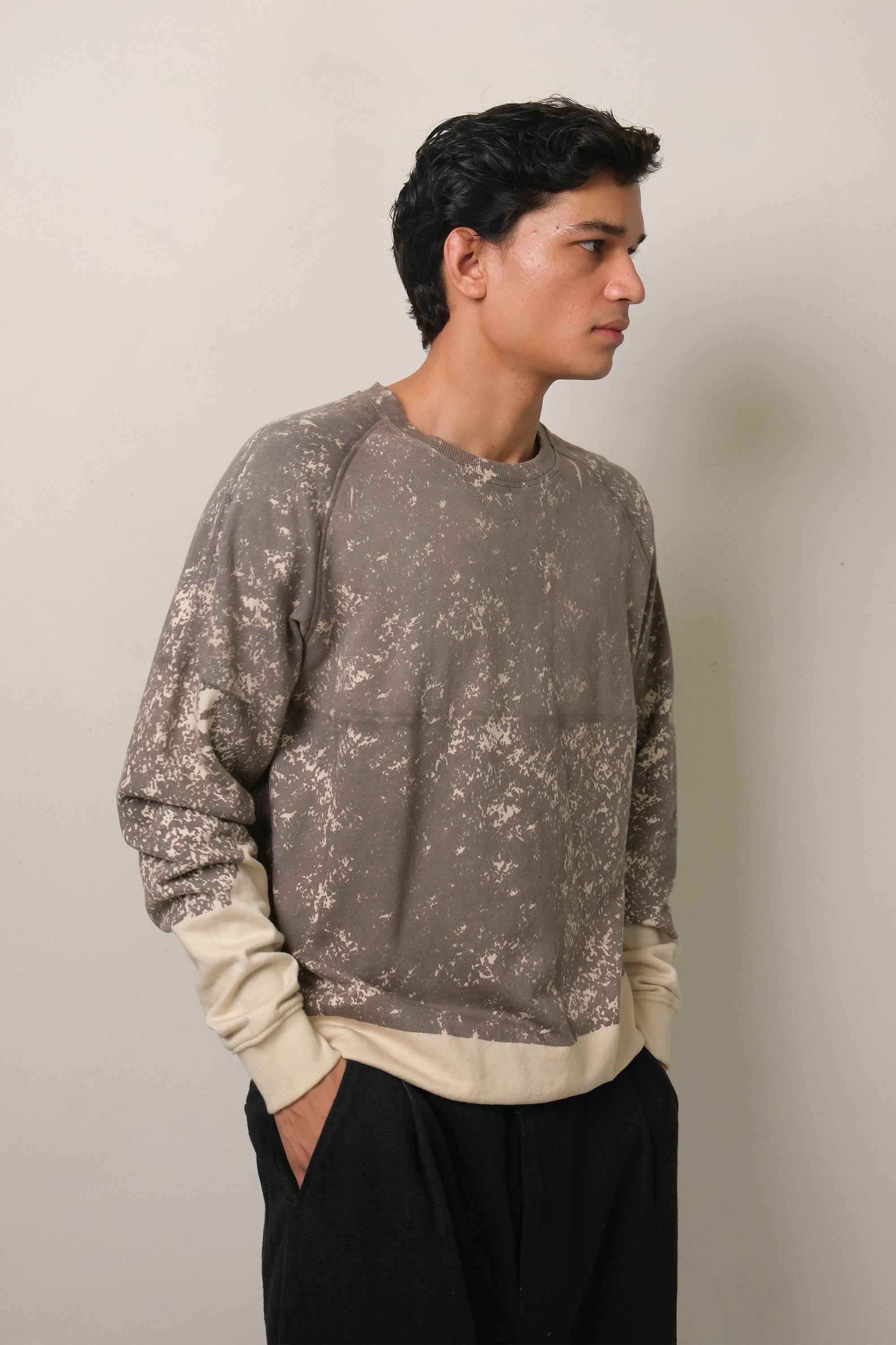 A man wearing charcoal screen printed sweatshirt