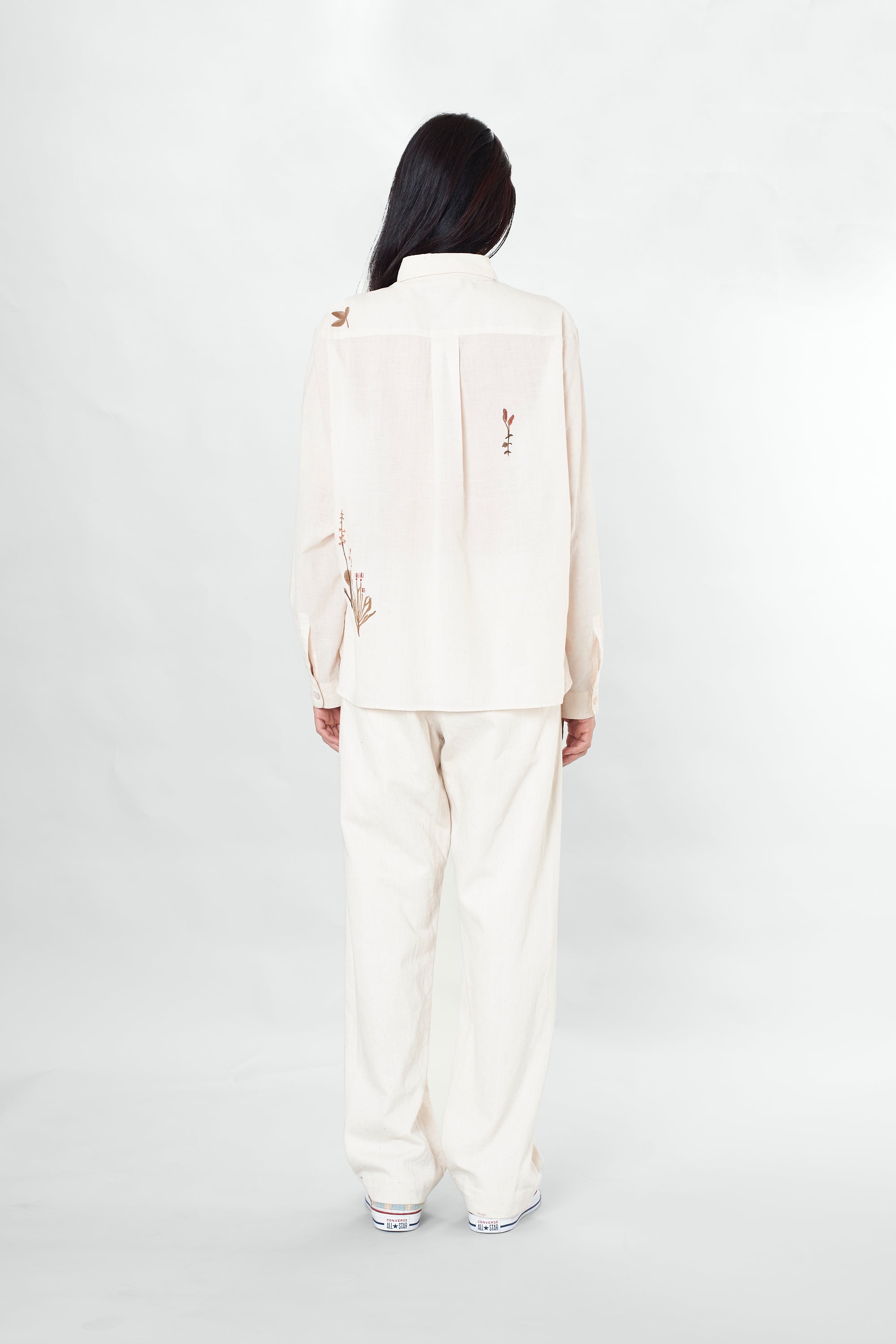 A back shot of a man wearing ecru cotton shirt