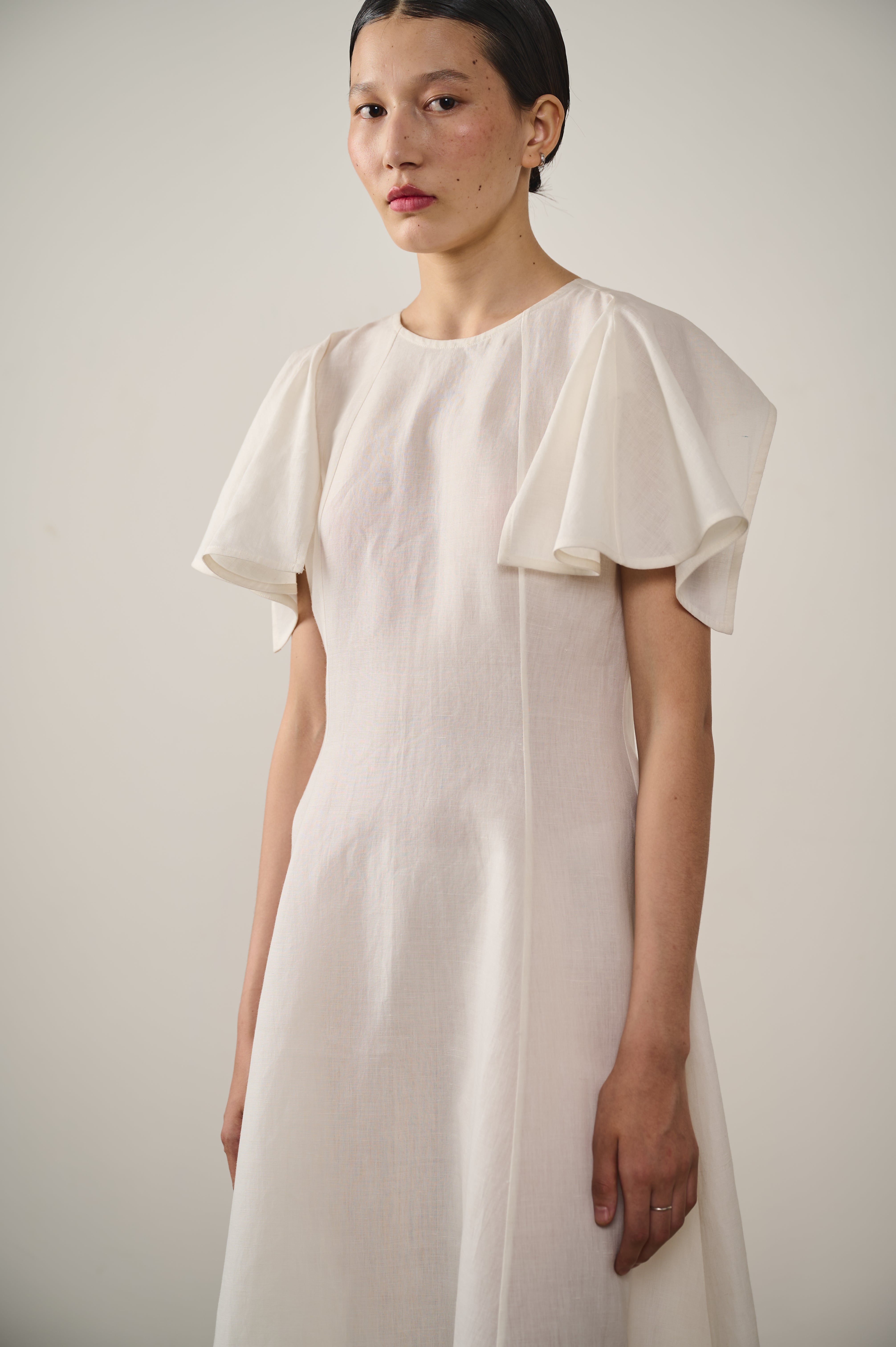 A woman wearing linen ecru dress