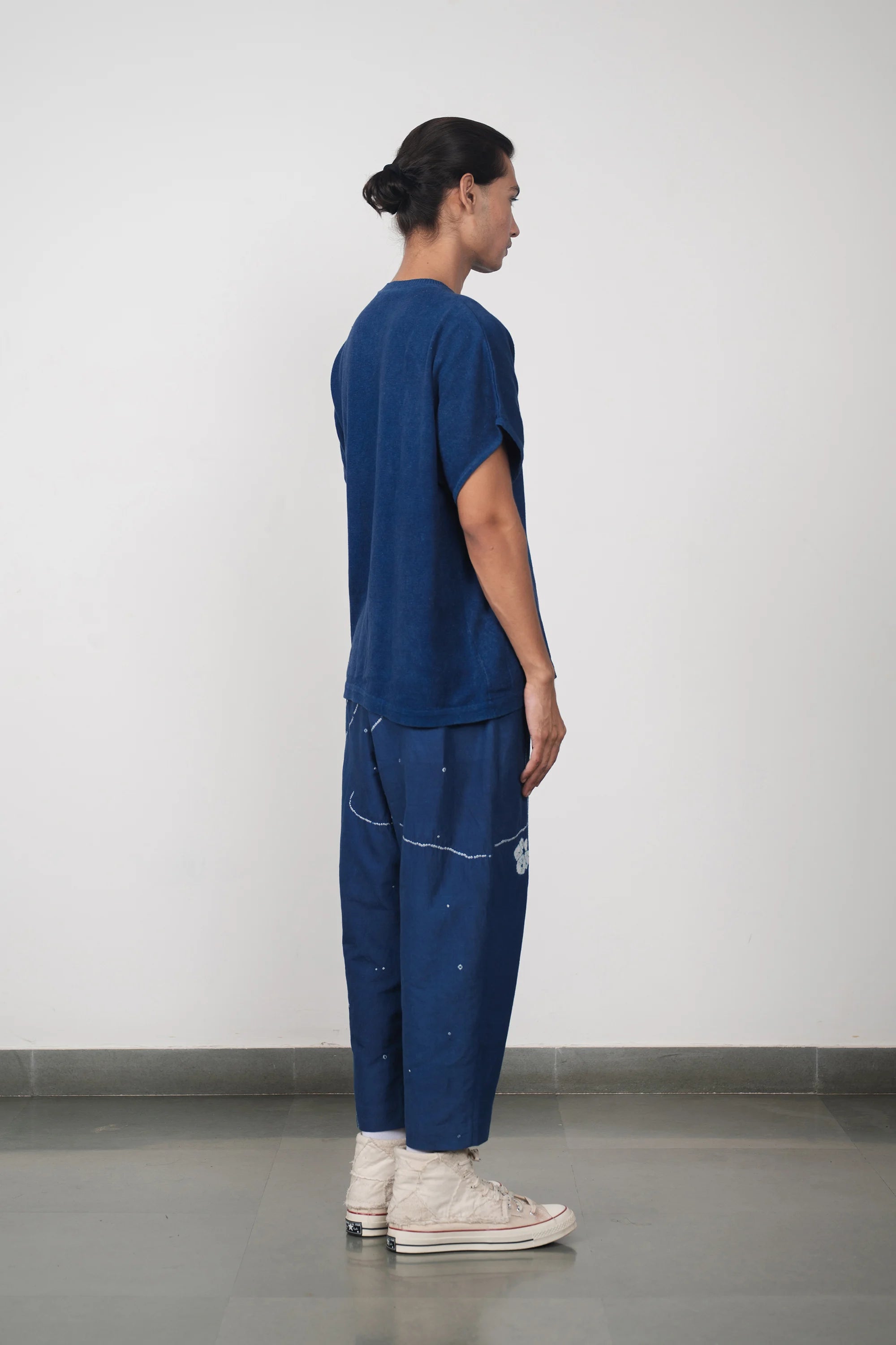 A side shot of a man wearing medium indigo t-shirt