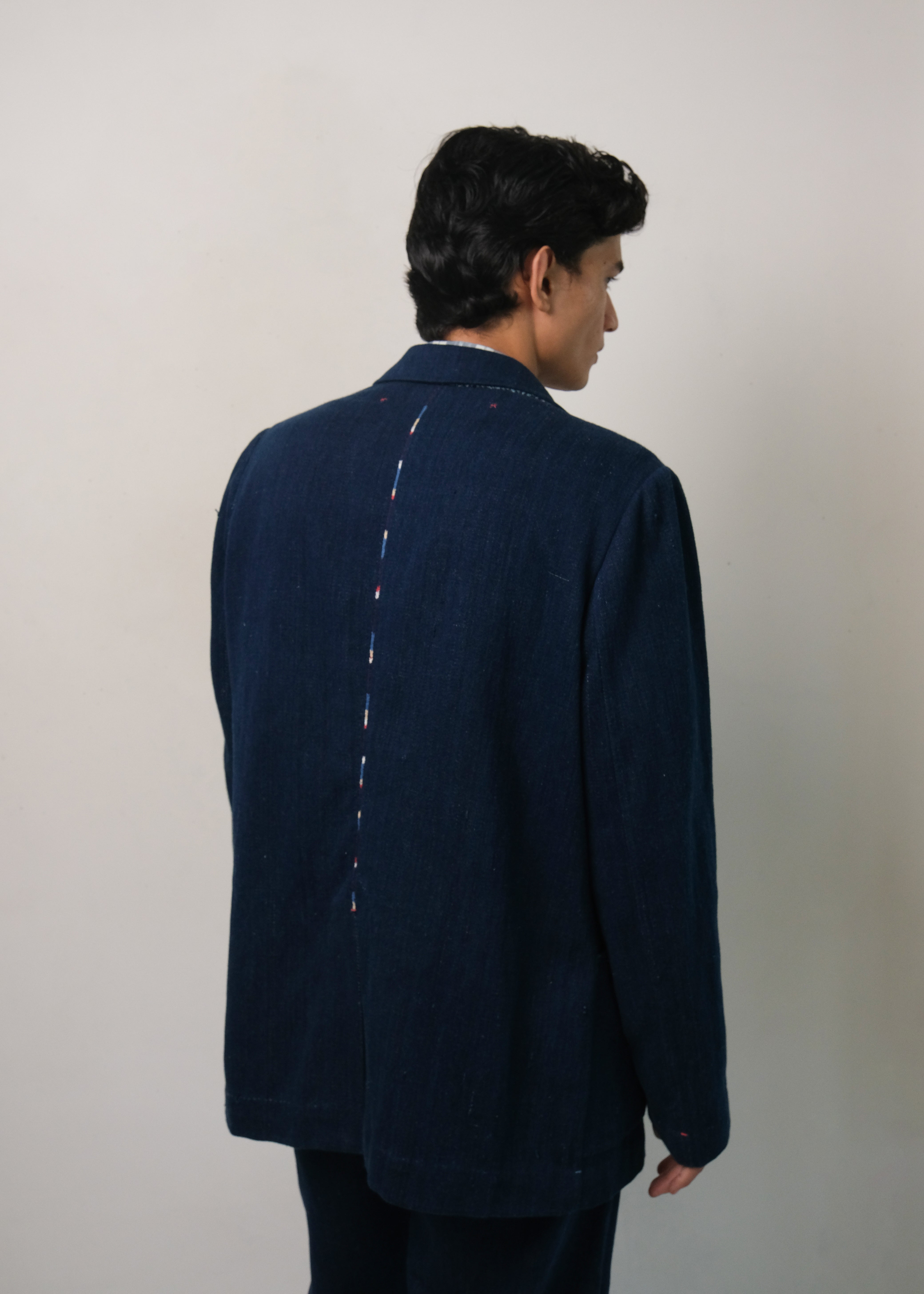 A back shot of a man wearing denim jacket