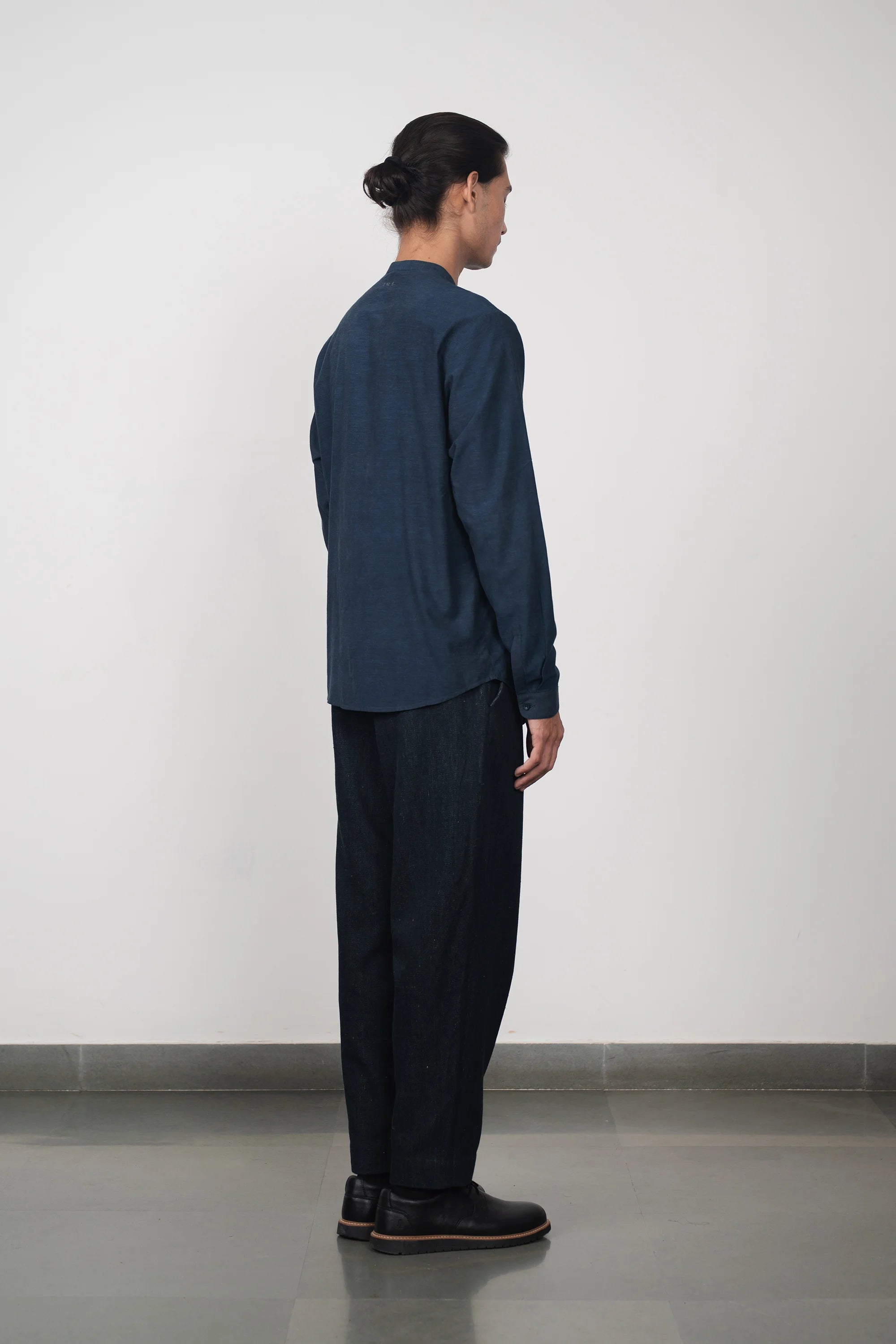 A back shot of a woman wearing estate blue shirt