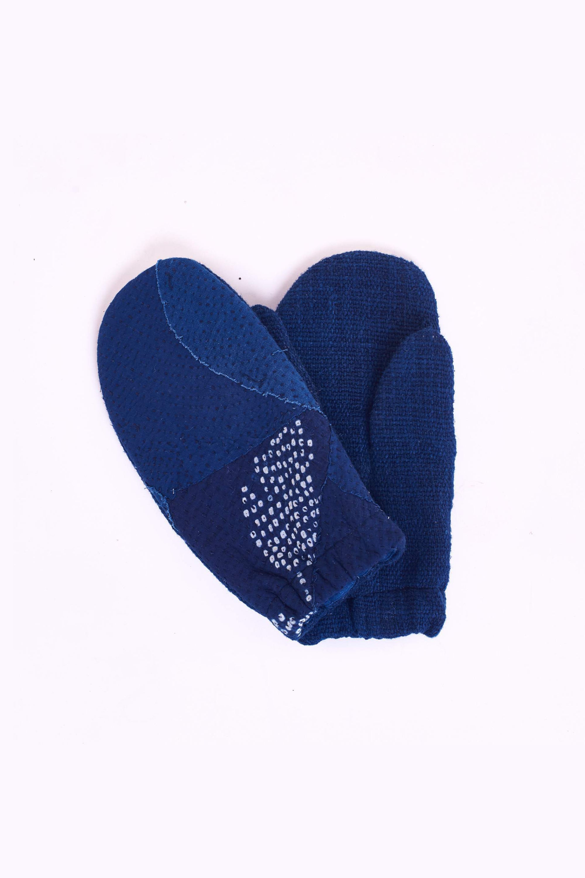 Indigo patchwork mittens on a light grey background