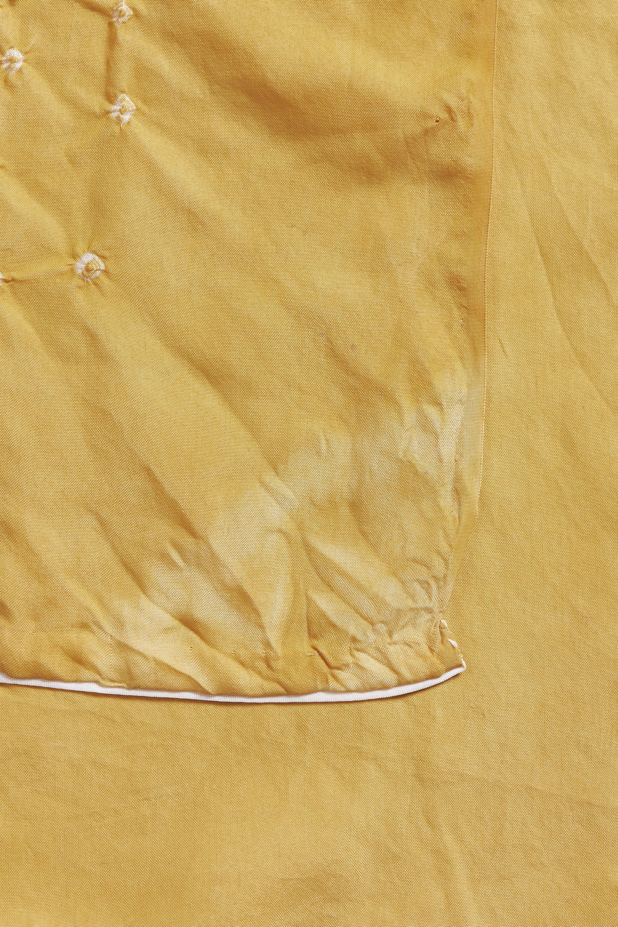 Close-up of a mustard yellow fabric with a subtle pattern