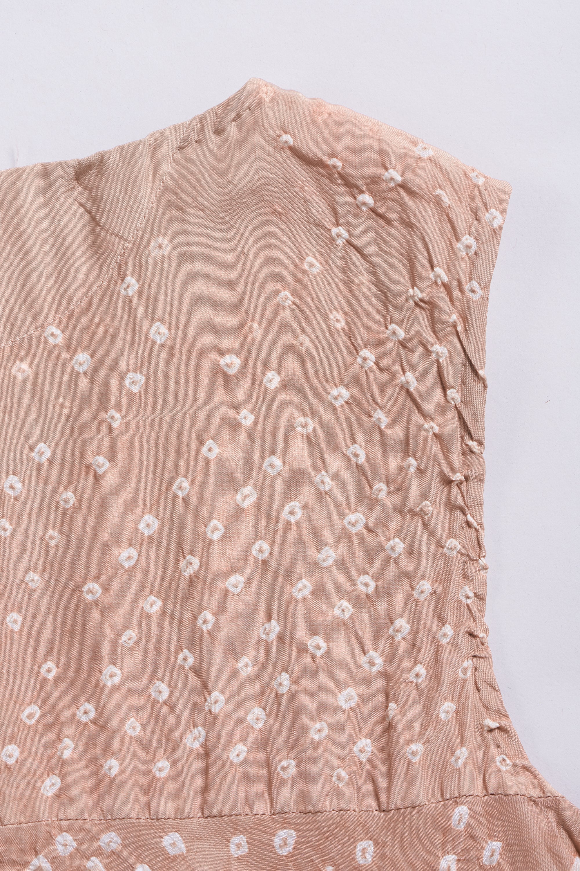 Light brown sleeveless top with white floral pattern