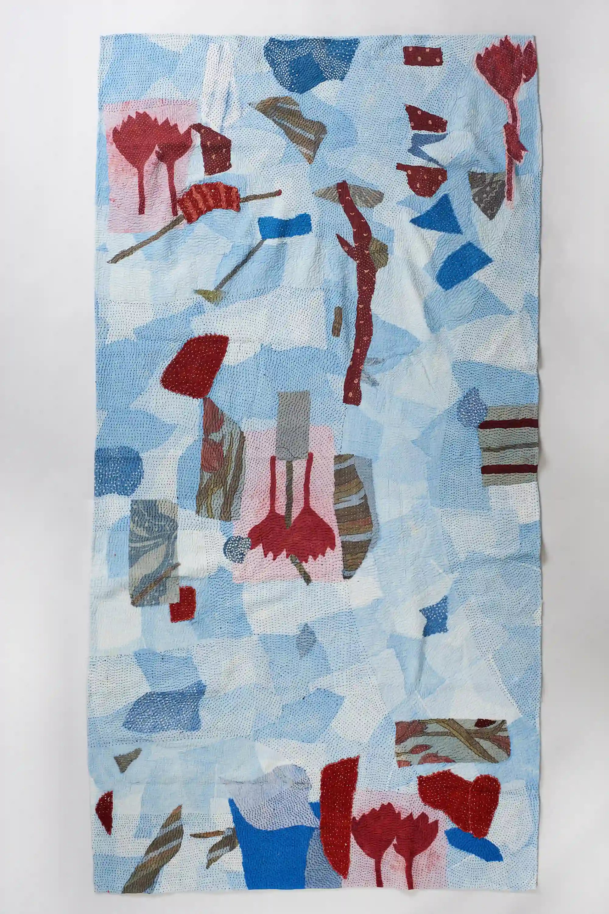 Shades of indigo patchwork kantha quilt on light grey background