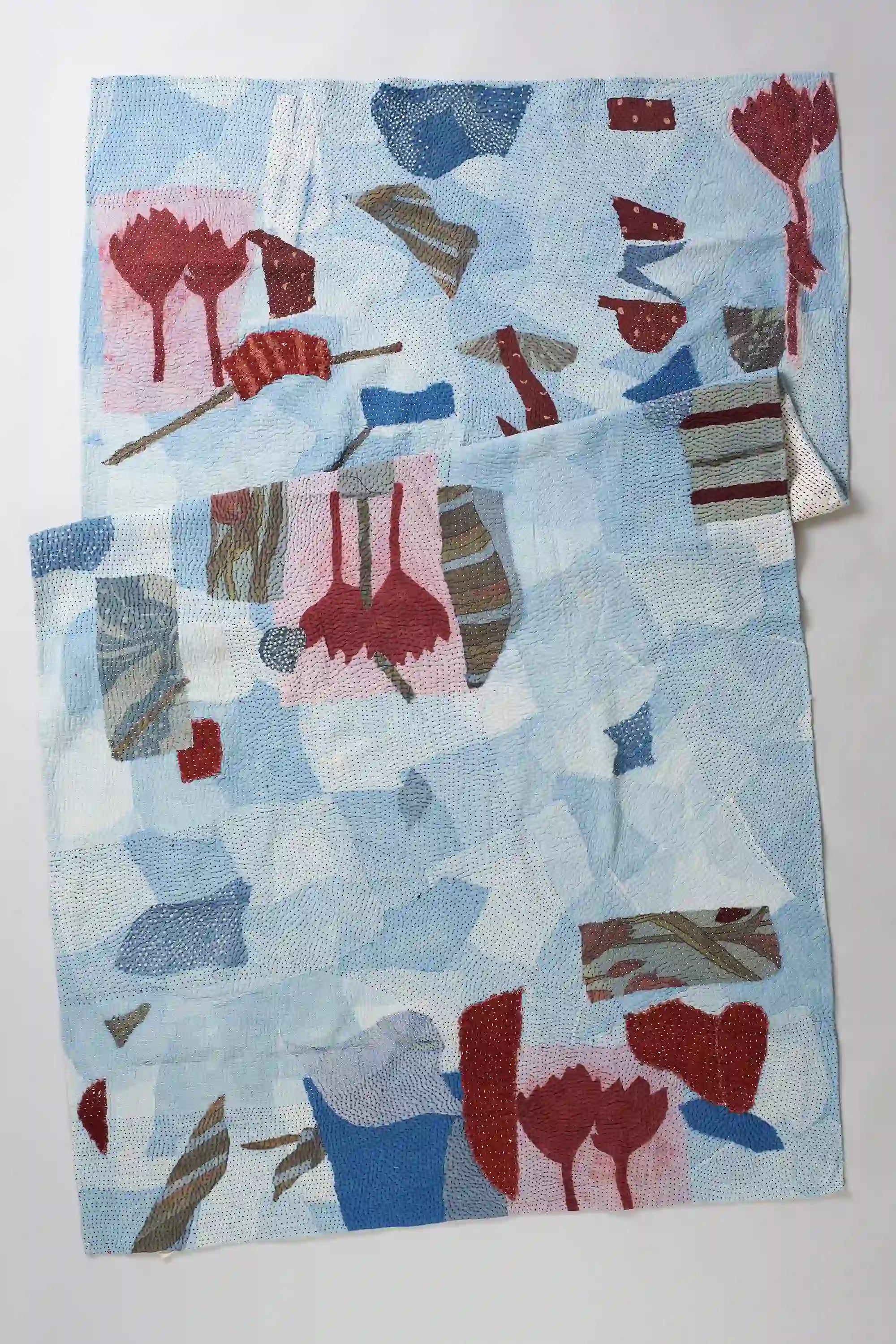 Folded indigo quilt on light grey background